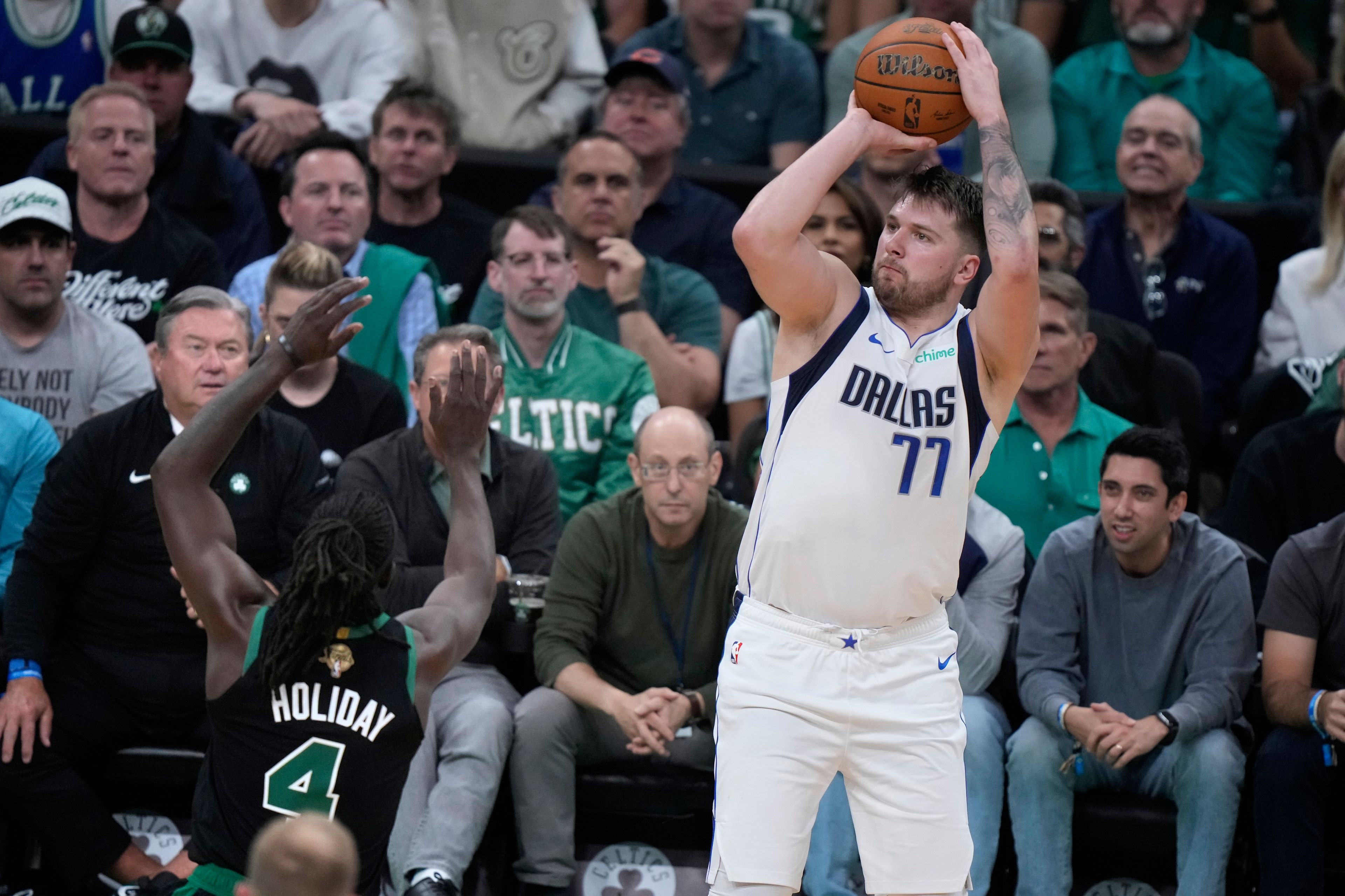 Dallas Mavericks guard Luka Doncic (77) looks to shoot over Boston Celtics guard Jrue Holiday (4) during the first half of Game 2 of the NBA Finals basketball series, Sunday, June 9, 2024, in Boston.