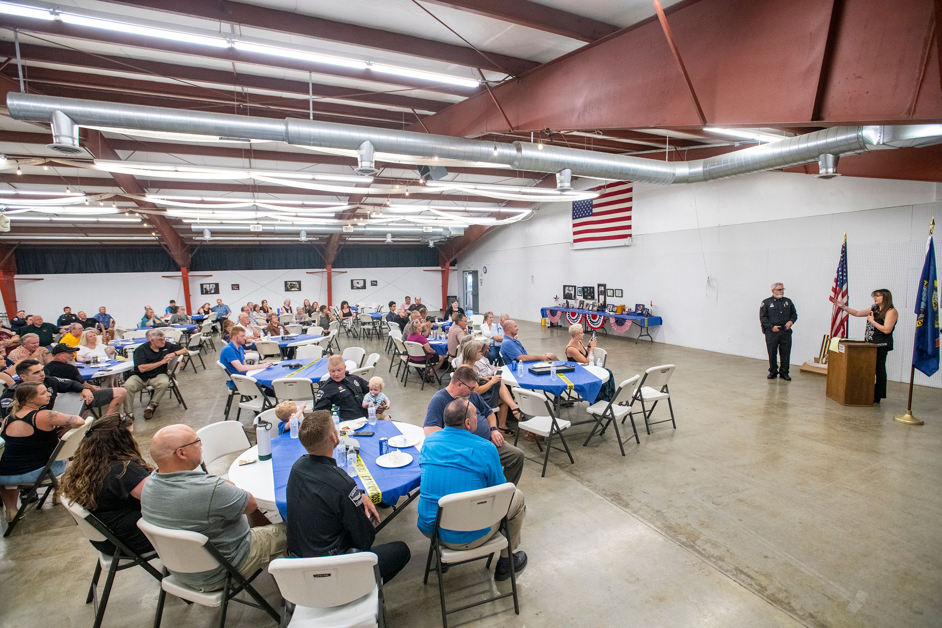 Guests listen as Belen Jordan speaks about her husband, Lt. Brannon Jordan, during Jordan’s retirement party Thursday at the Latah County Fair Office in Moscow.