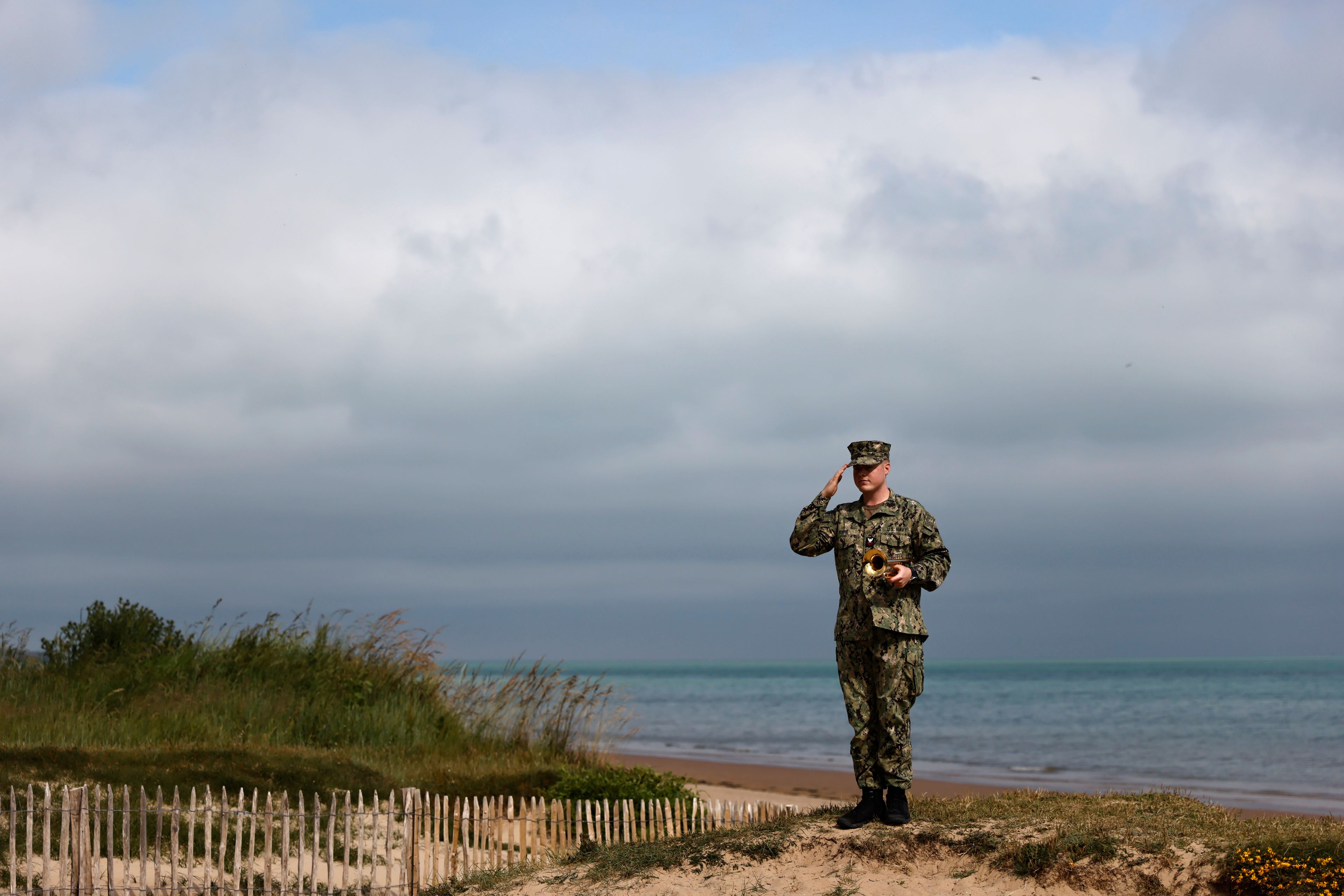 An American US Navy soldier salutes on Omaha Beach, Tuesday, June 4, 2024 in Normandy. Veterans and world dignitaries gather in Normandy to commemorate the 80th anniversary of the landings. (AP Photo/Jeremias Gonzalez)