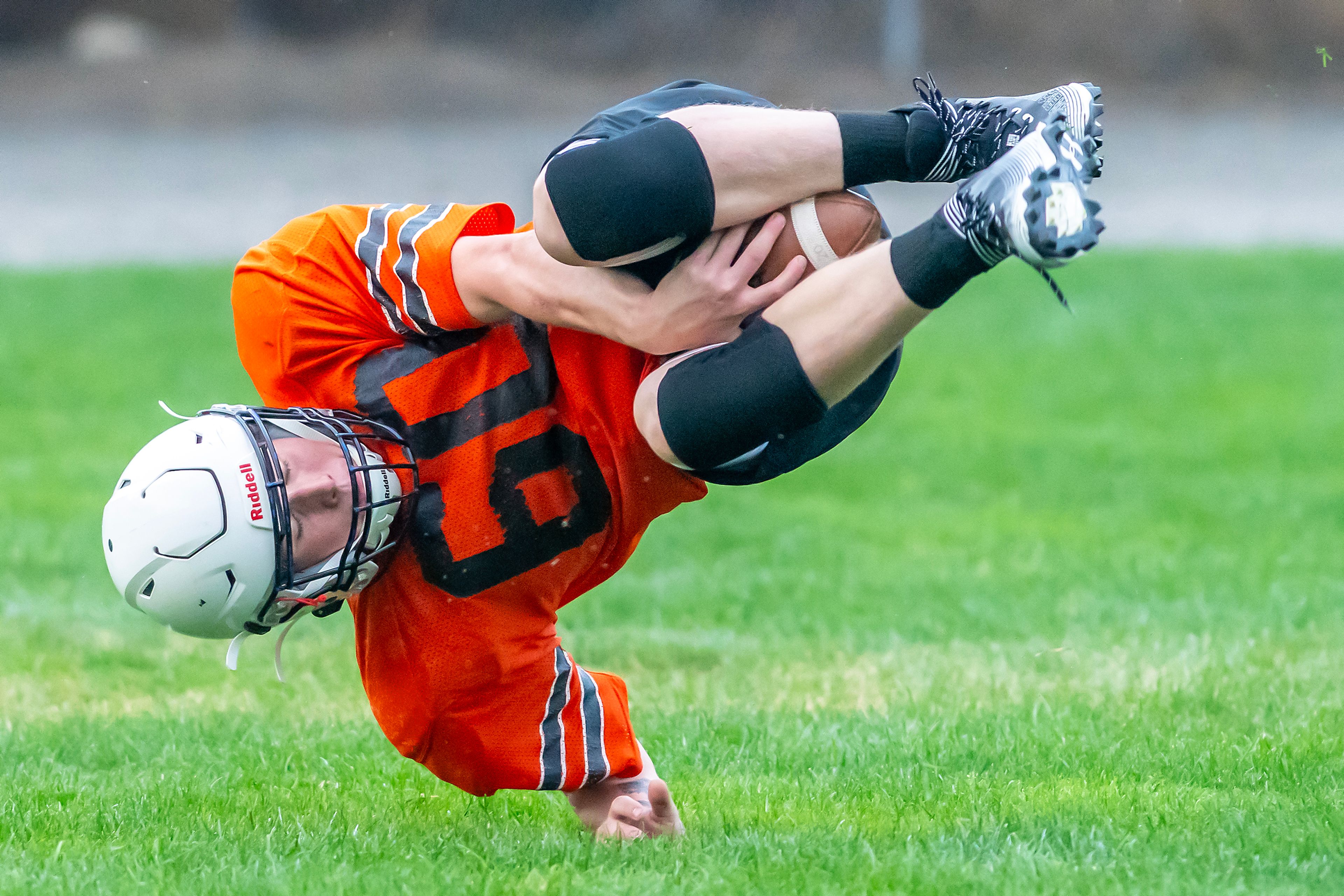 Treyson Hendrickson holds onto a catch as he rolls over at football practice Monday in Asotin.