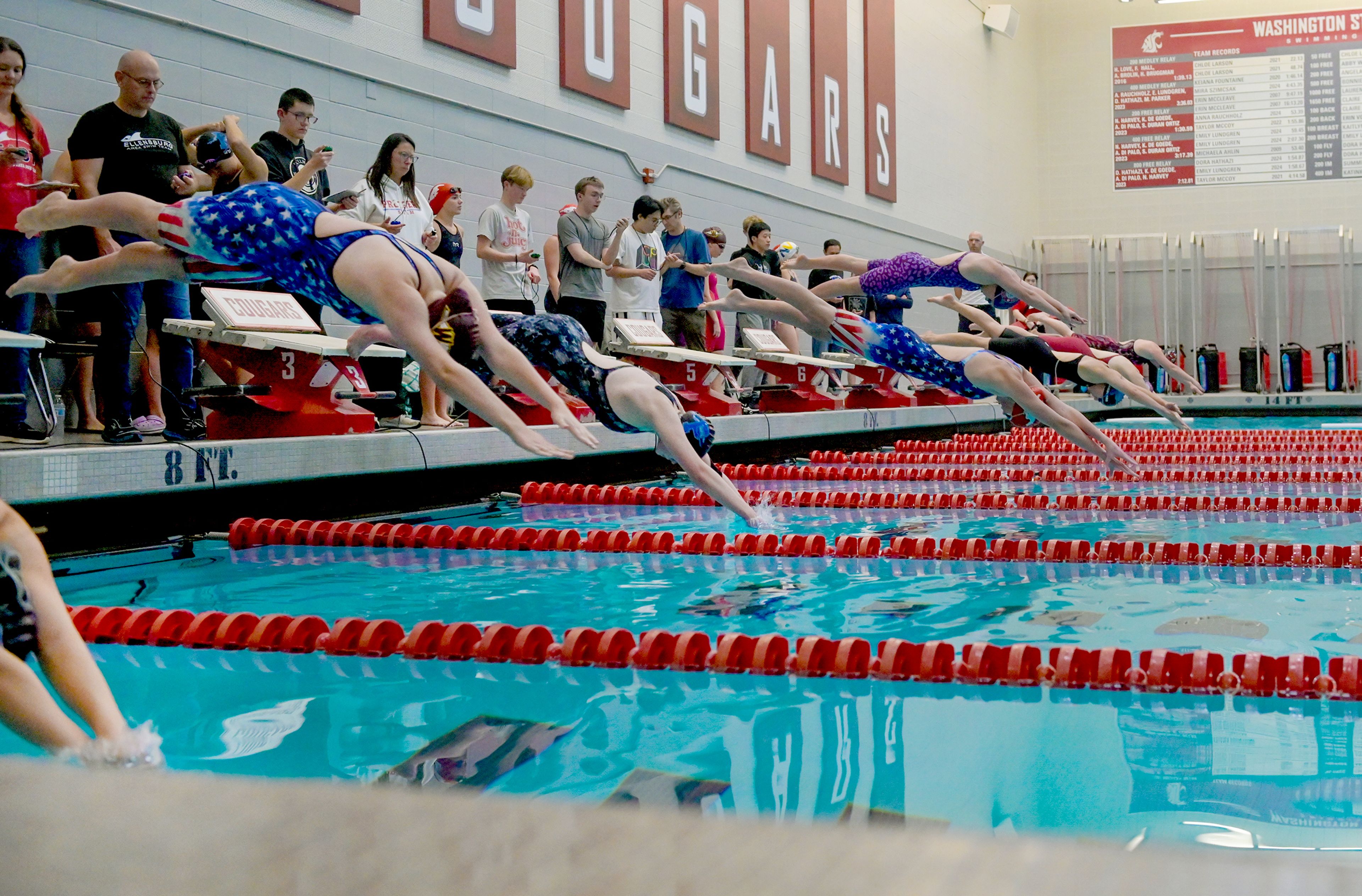 Swimmers, including three lanes filled with Pullman team members, dive to begin a 50-yard freestyle Thursday at the Eastern Washington District Swim Championship at Washington State University in Pullman.