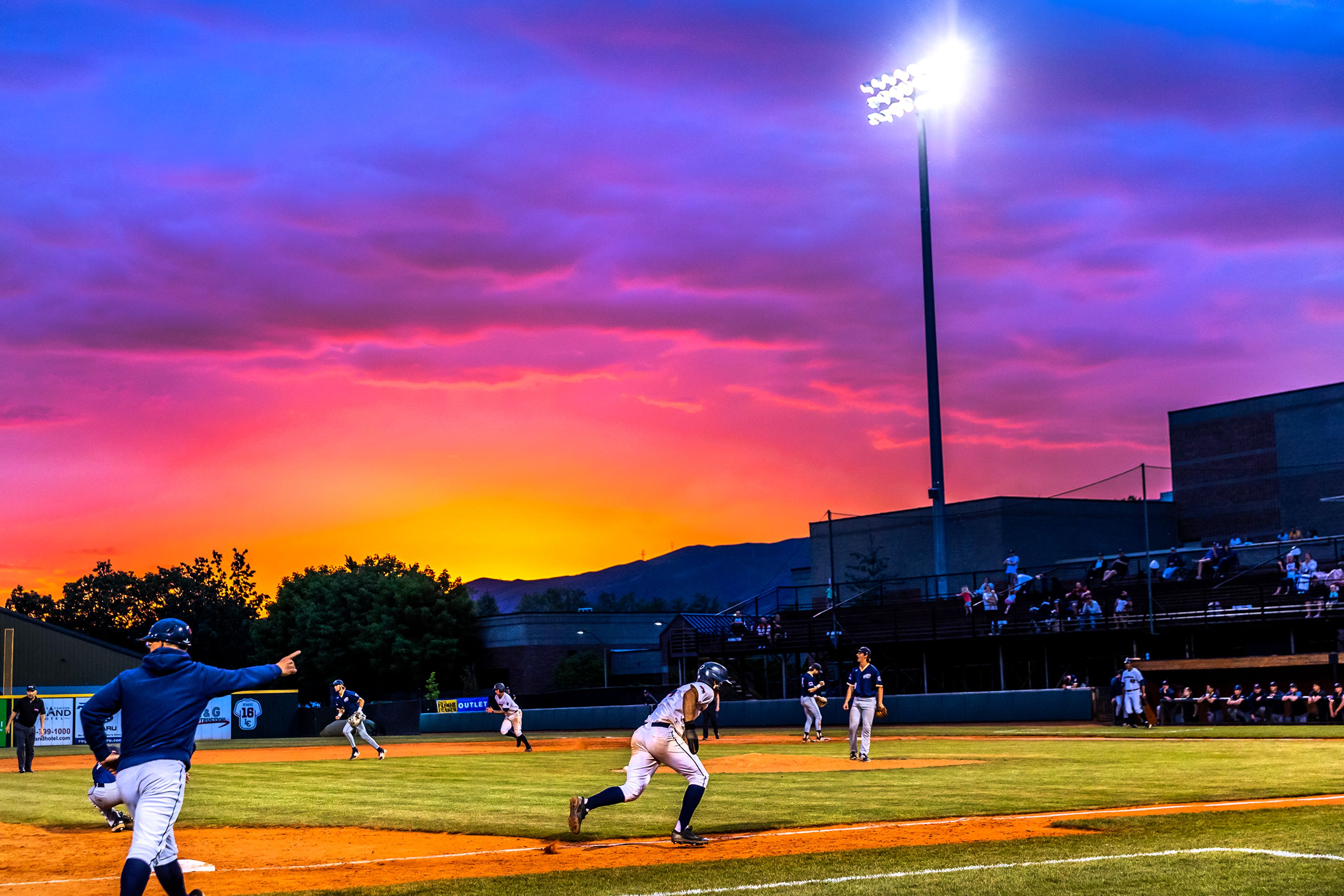 Lewis-Clark State’s Dominic Signorelli takes off running for home as UBC third baseman Aaron Marsh misses a catch in an inning of a first round game of the NAIA Opening Round Monday at Harris Field in Lewiston.