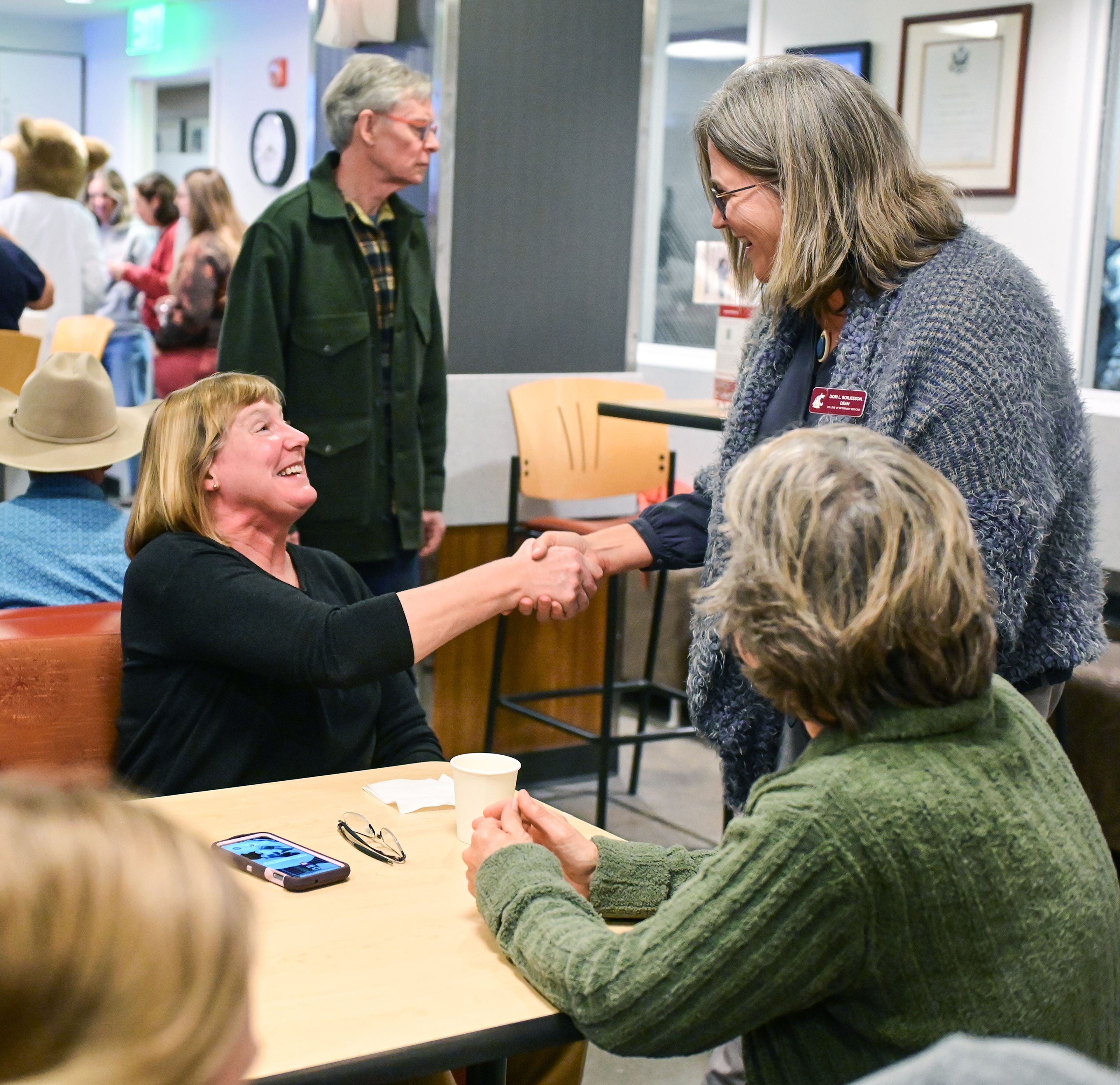 Leslie Dahl, left, a 1989 graduate of the Washington State University College of Veterinary Medicine, shakes hands with Dean Dori Borjesson at a 125th celebration for the school Friday in Pullman.,