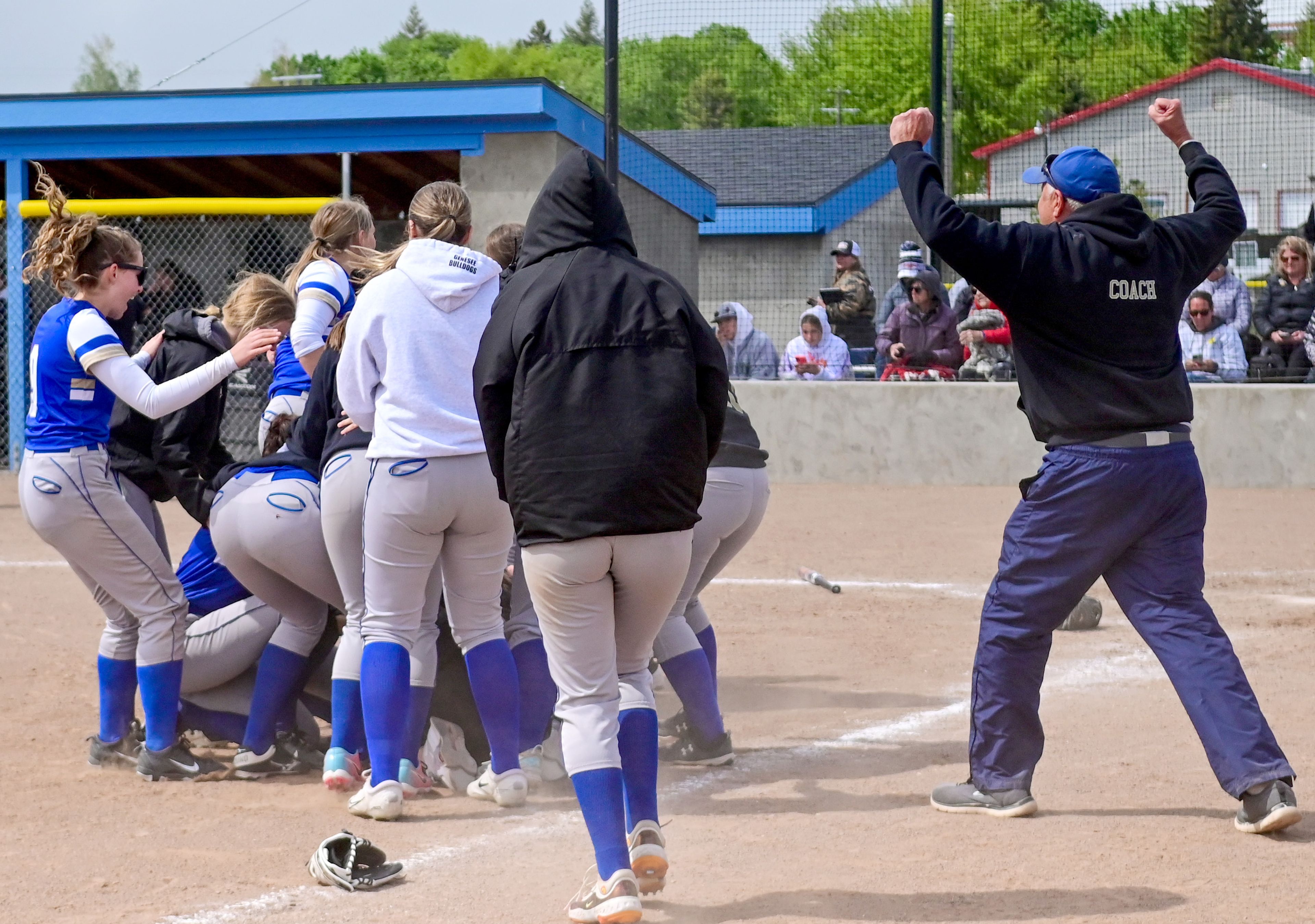 Genesee players and coaches run to the dogpile to celebrate winning an Idaho Class 1A state championship game Friday in Genesee.