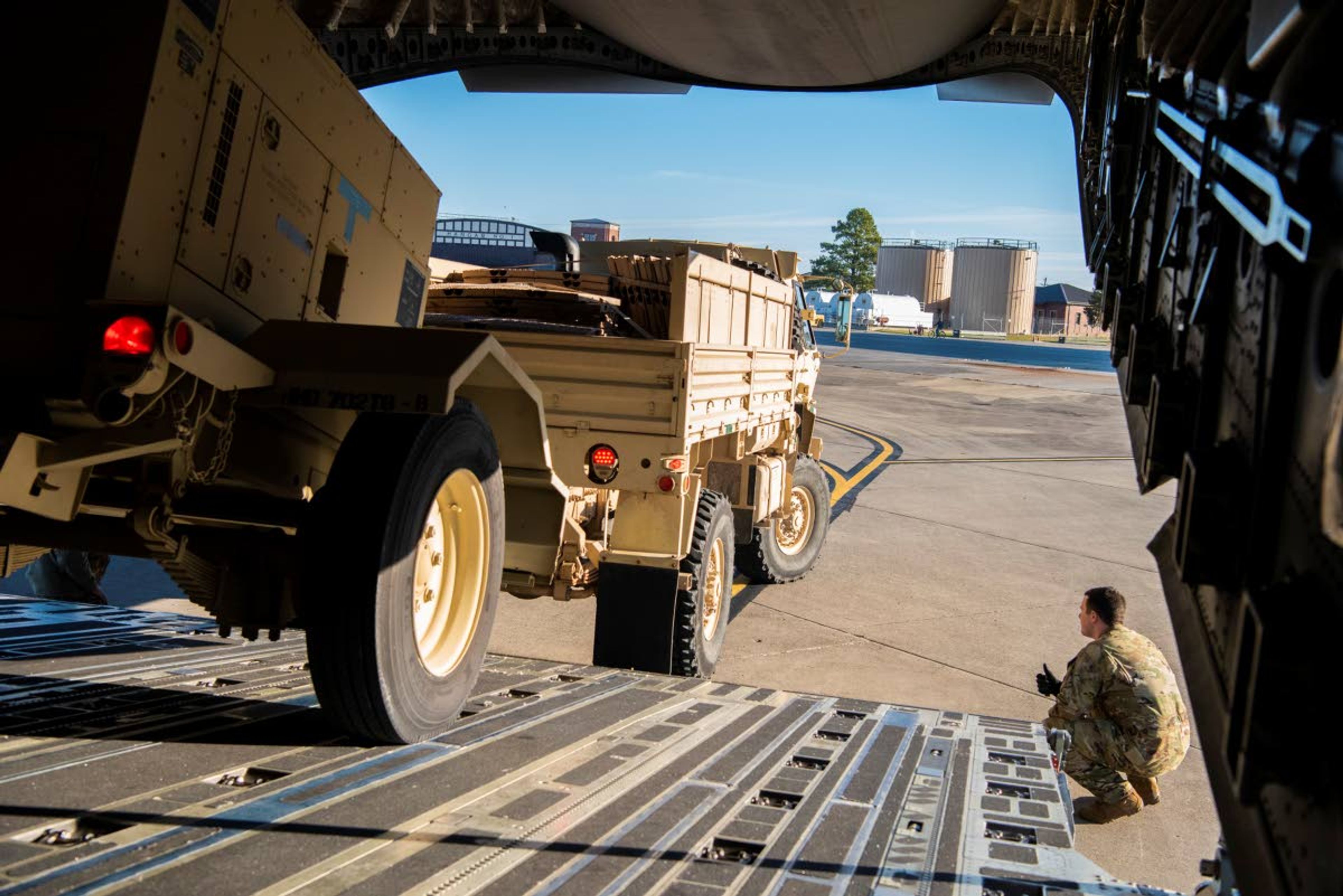 This Oct. 29, 2018 photo provided by the U.S. Air Force shows Airman 1st Class Trevor Pearce helping guide a military vehicle into the cargo compartment of a C-17 Globemaster III at Fort Knox, Kentucky. The aircrews provided strategic airlift to Headquarters Company, 89th Military Police Brigade, Task Force Griffin, which is deploying to the Southwest border region to support law enforcement agencies as they conduct coordinated efforts to secure the border. (Airman 1st Class Zoe M. Wockenfuss/U.S. Air Force via AP)