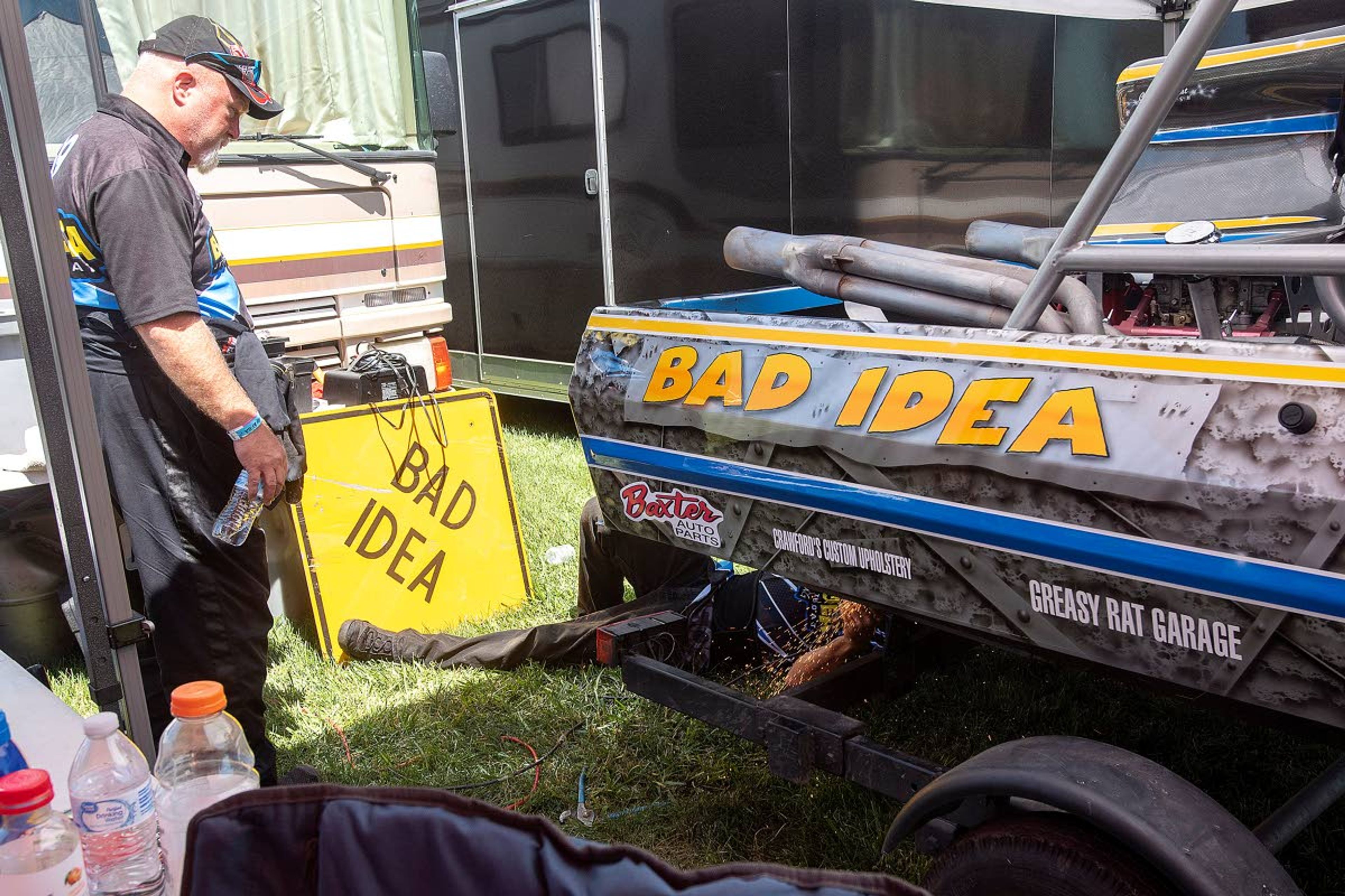 Bad Idea driver Eric Petring, of Clarkston, looks on as modifications are made to his sprint boat while in the pits in between qualifying-heat runs at Webb's Slough in St. John on Saturday.