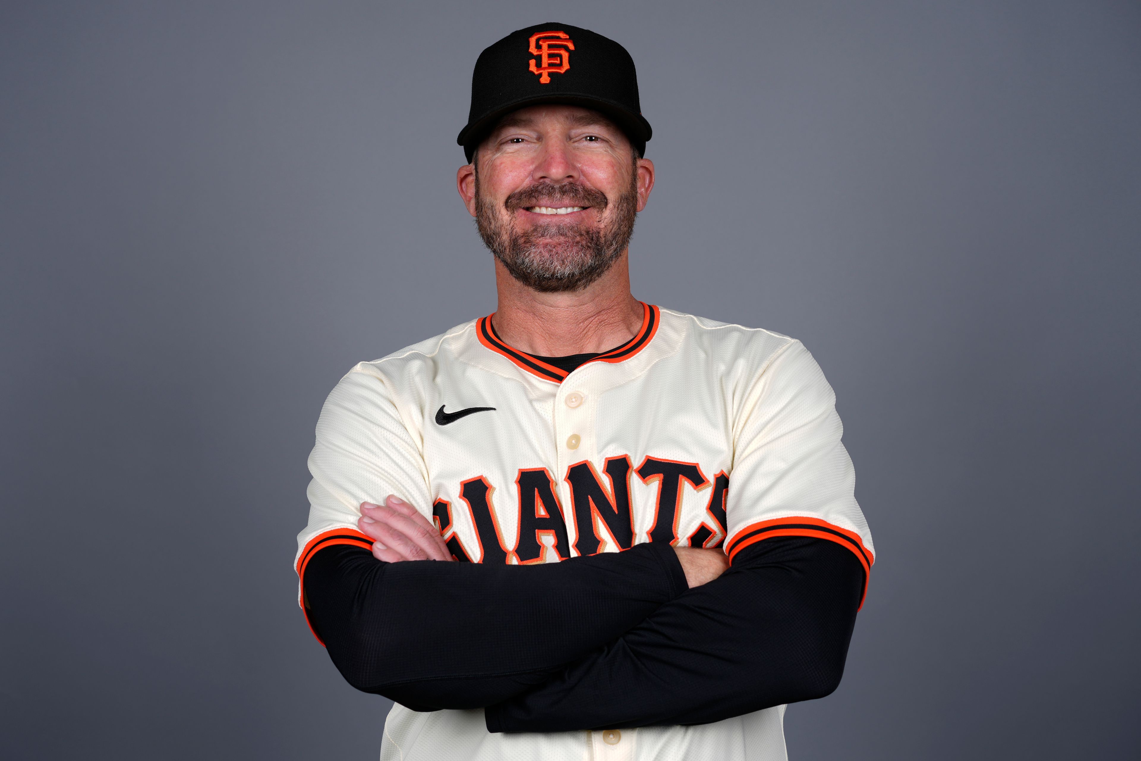 FILE - Ryan Christenson of the San Francisco Giants baseball team poses Feb. 21, 2024, in Scottsdale, Ariz. Ryan Christenson has turned lineup cards into art. After San Francisco Giants manager Bob Melvin picks a batting order, his bench coach selects the font and color scheme for the day’s sumptuous script. Options include Roman Gothic, Celtic variations, Chicano Tattoo and graffiti. “He’s an artist,” said New York Yankees star Juan Soto, who spent 1 1/2 years with Christenson in San Diego.