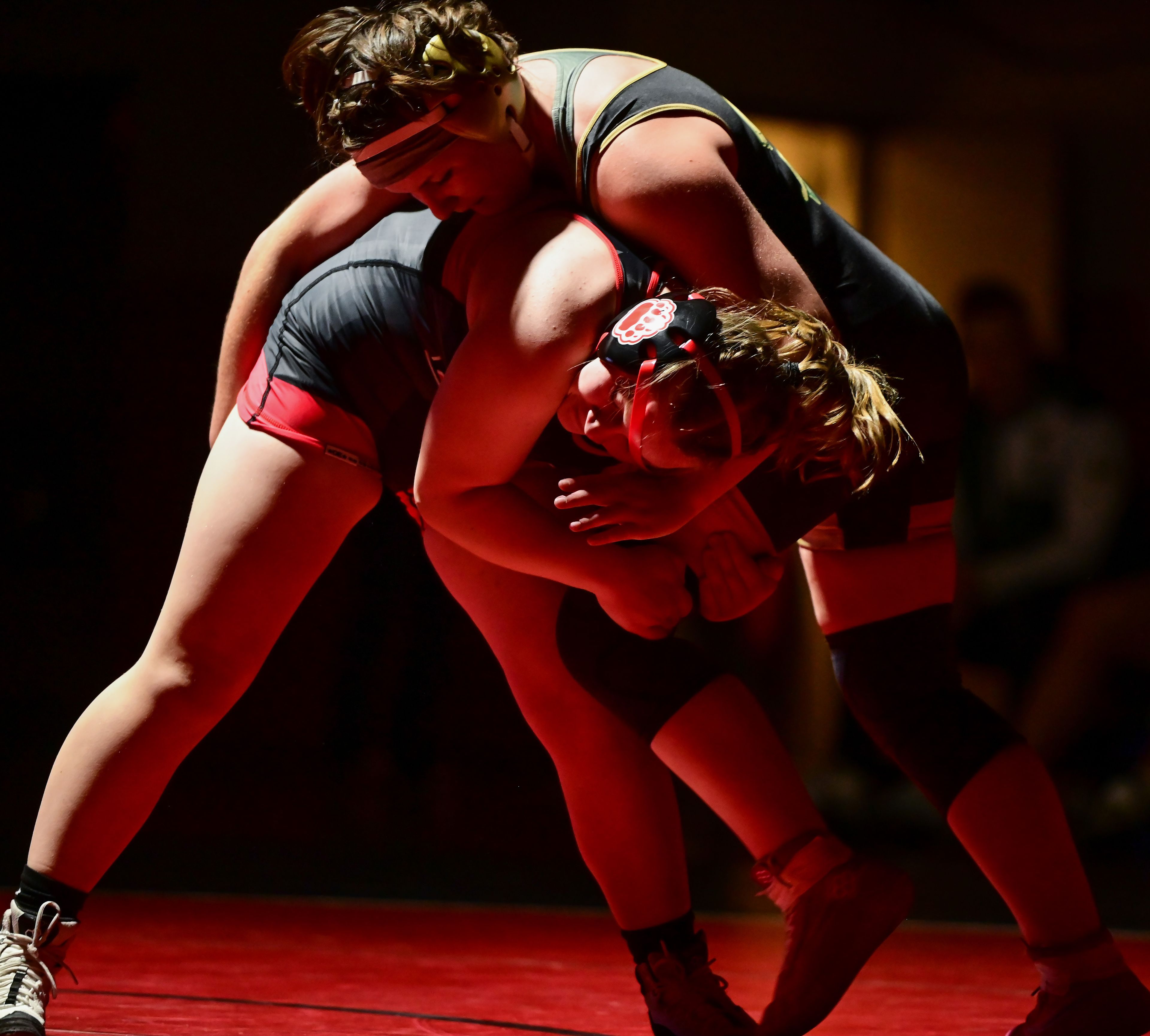 Moscow’s Hayden Palmer holds on to the leg of St. Maries' Eavan Johnson during a match Thursday at Bear Den in Moscow.