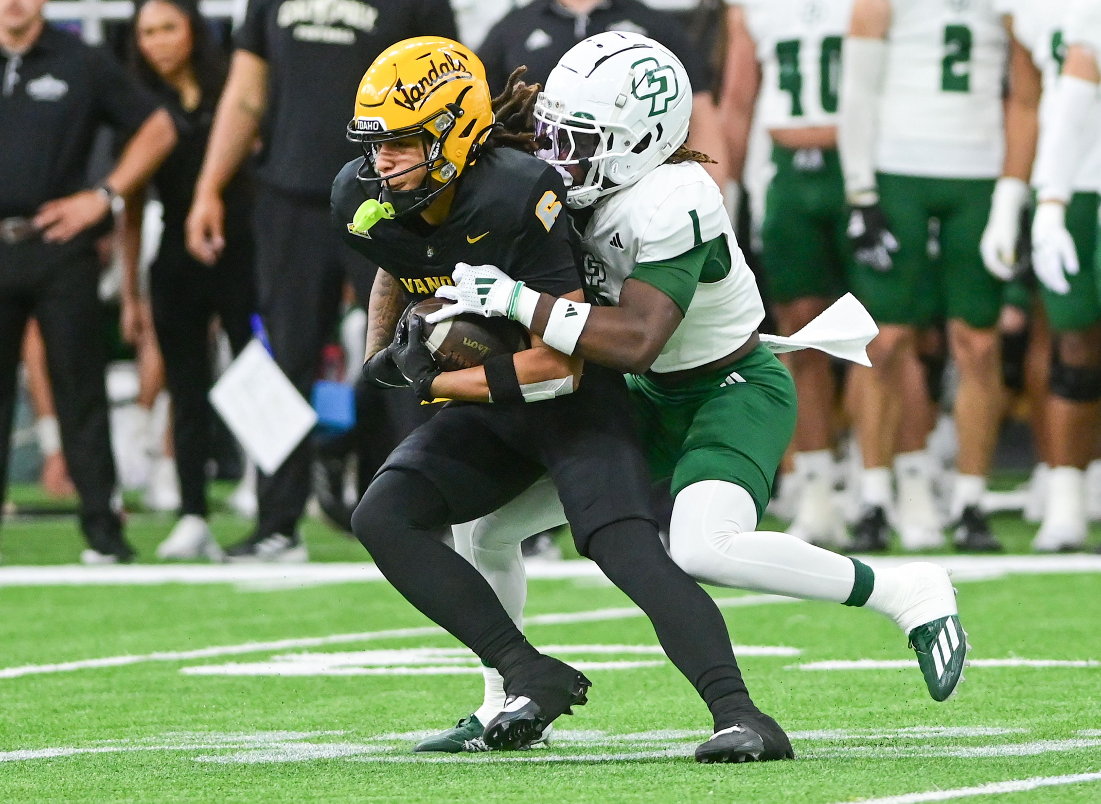 Idaho wide receiver Jordan Dwyer completes a pass before being tackled by Cal Poly cornerback Delano Franklin Saturday at the P1FCU Kibbie Dome in Moscow.,