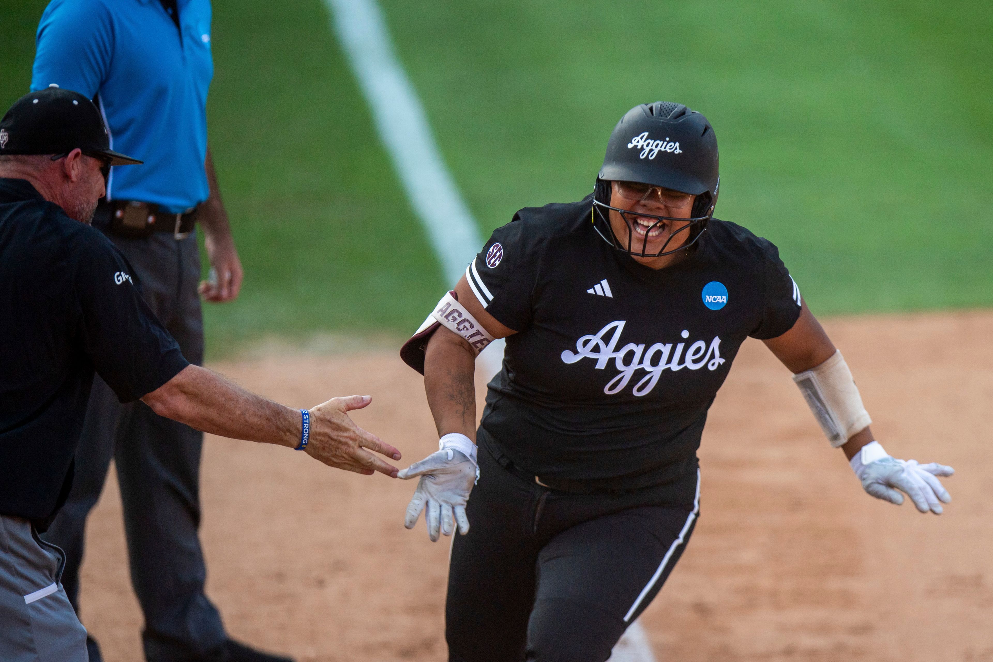 Texas A&M's Mya Perez, right, celebrates after a three-run home run against Texas in the seventh inning in Game 2 of the NCAA college Division I softball tournament super regional in Austin, Texas, Saturday May 25, 2024.