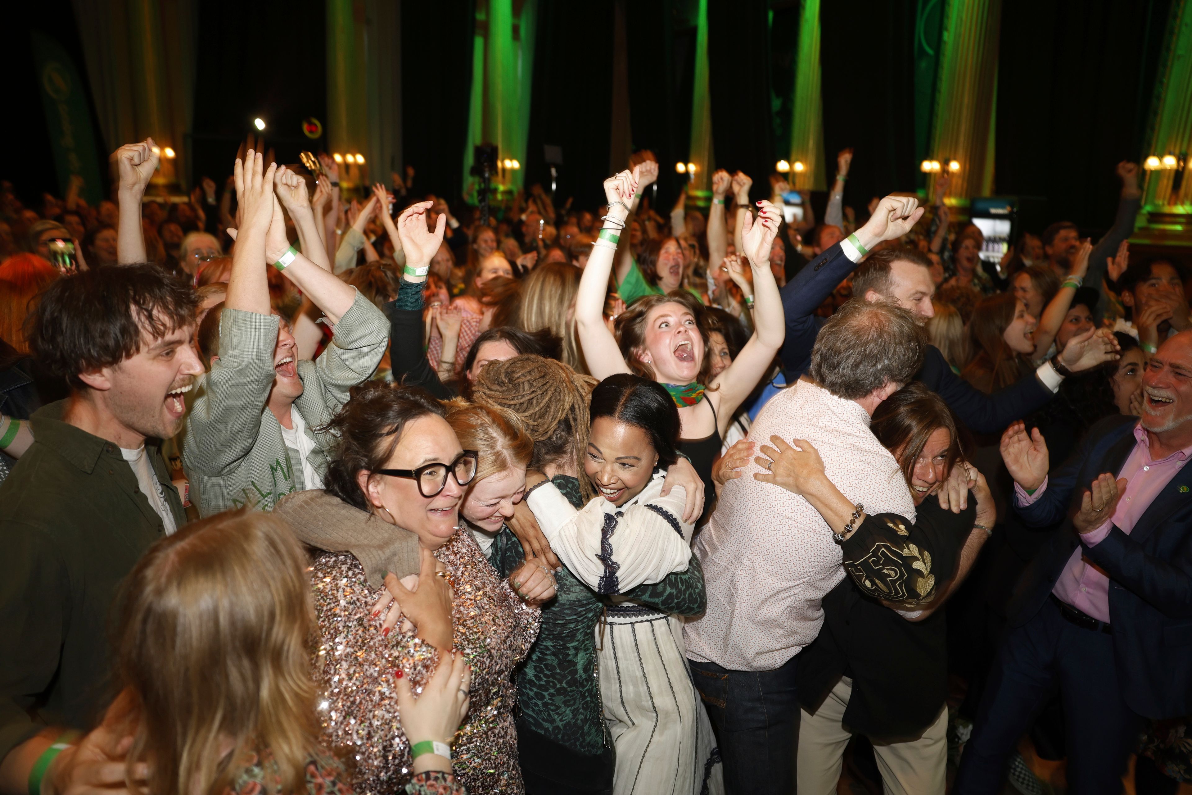 Green Party secretary Katrin Wissing, lower left wearing eyeglasses, celebrates with a supporter while spokeswoman Amanda Lind, center left, hugs top candidate Alice Bah Kuhnke, center right facing camera, and top candidate Pär Holmgren, back turned to camera, hugs a supporter as Green Party members celebrate as the results of the polling station survey come in at the Green Party's vigil at Nalen in Stockholm.