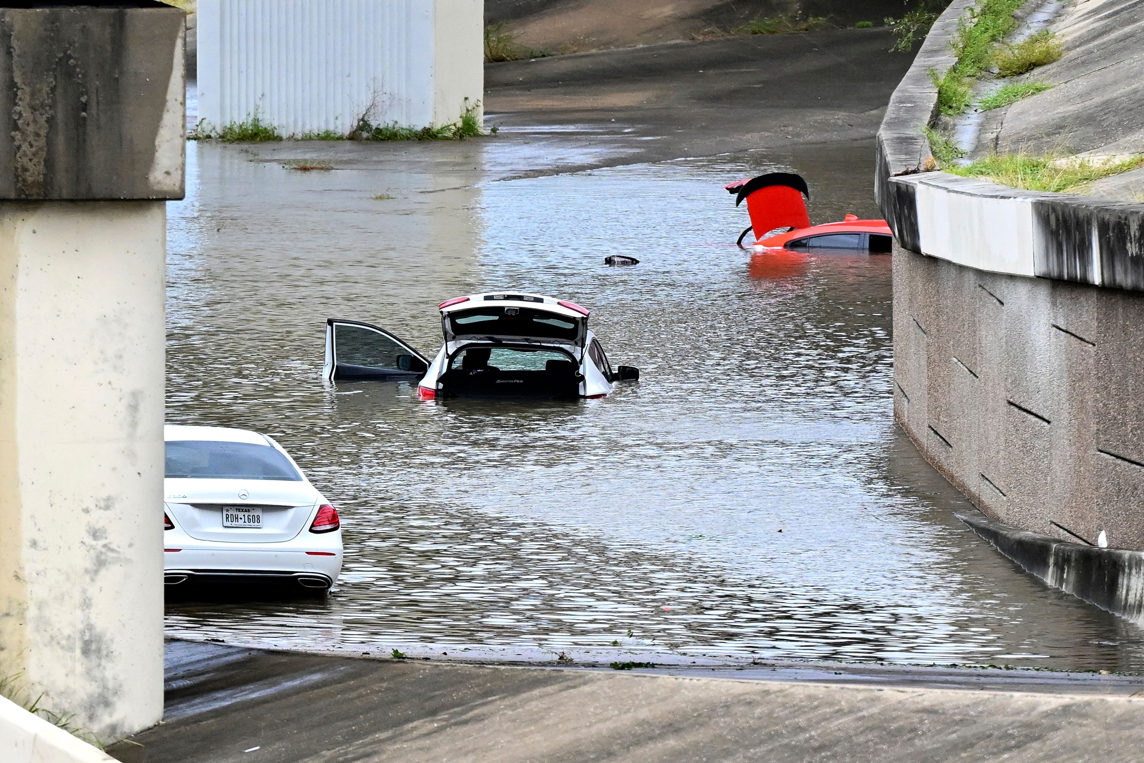 Buffalo Bayou floods stranding vehicles near Downtown Houston after Beryl came ashore in Texas as a hurricane and dumped heavy rains downtown. (AP Photo/Maria Lysaker)