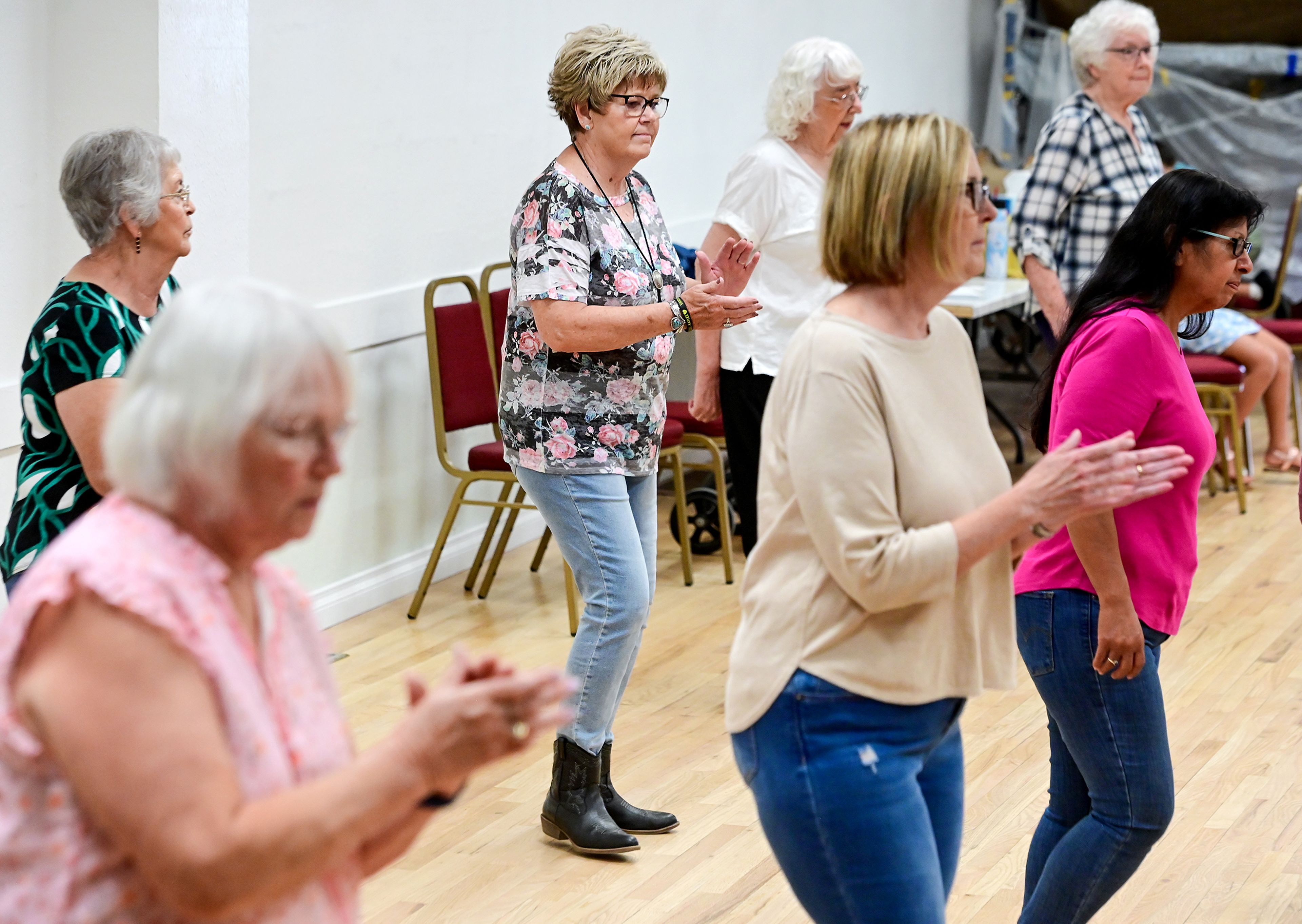 Vicki Bloom, center, claps while moving through the choreography of a line dance on Wednesday during the weekly line dancing class at Sixth Street Senior Center in Clarkston.