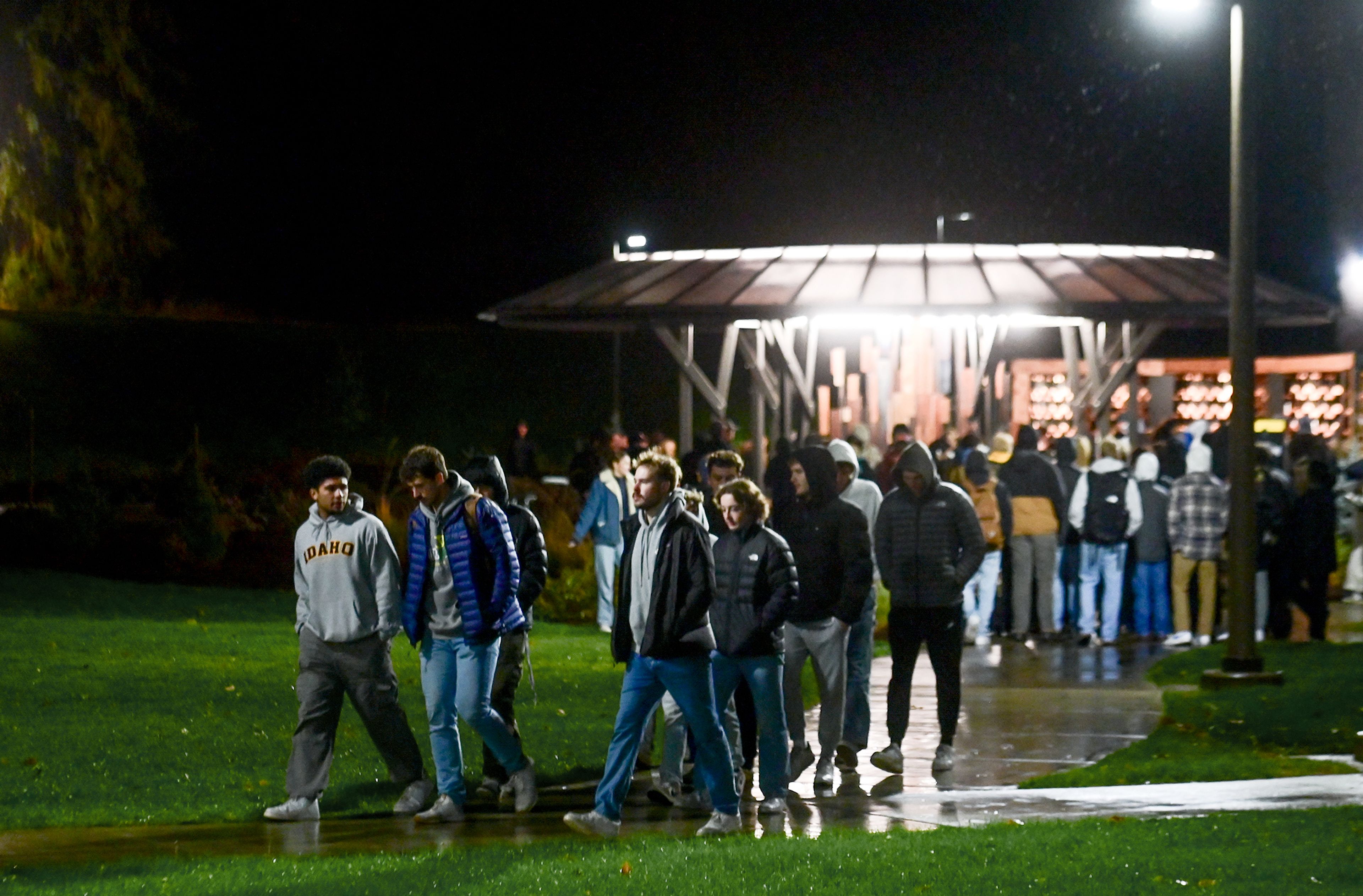 Those gathered for a vigil marking two years since the murder of four University of Idaho students begin to leave the Vandal Healing Garden and Memorial after spending time in the space holding candles and writing notes Wednesday in Moscow.