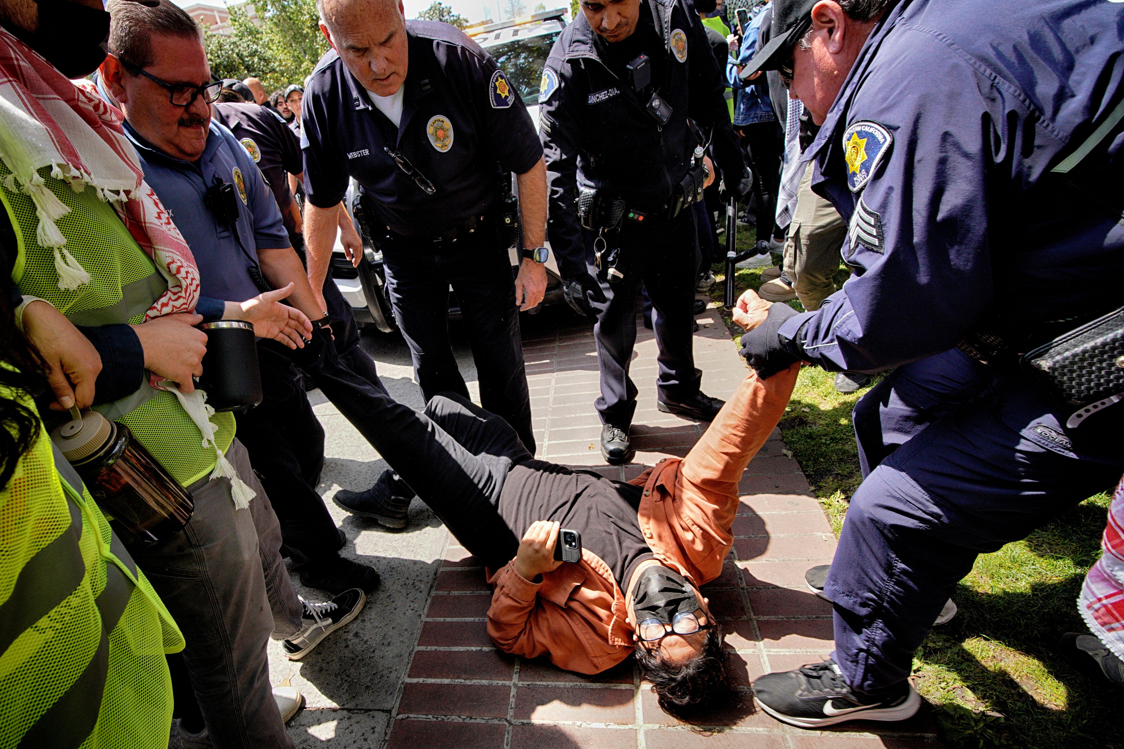 FILE - A University of Southern California protester is detained by USC Department of Public Safety officers during a pro-Palestinian occupation at the campus' Alumni Park, April 24, 2024, in Los Angeles.