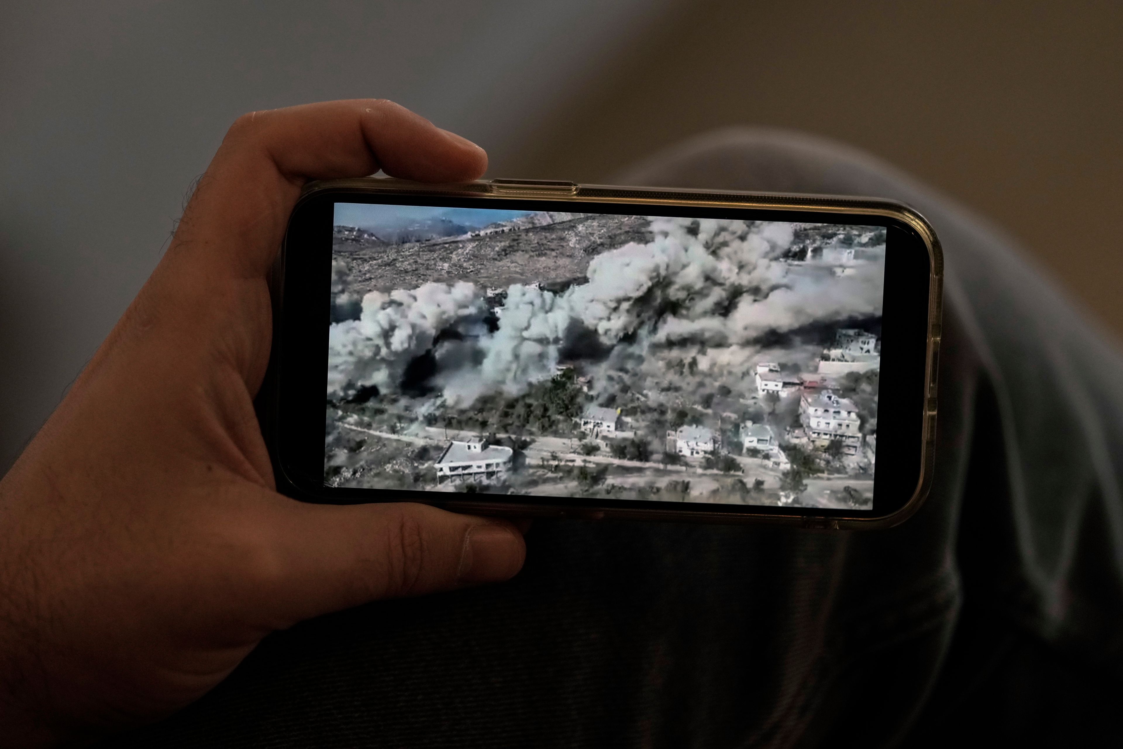 Lubnan Baalbaki shows a video released by the IDF as they blew up his village of Odeiseh during an interview with The Associated Press at his house in Geitawi, Beirut, Lebanon, Thursday, Oct. 31, 2024. (AP Photo/Bilal Hussein)