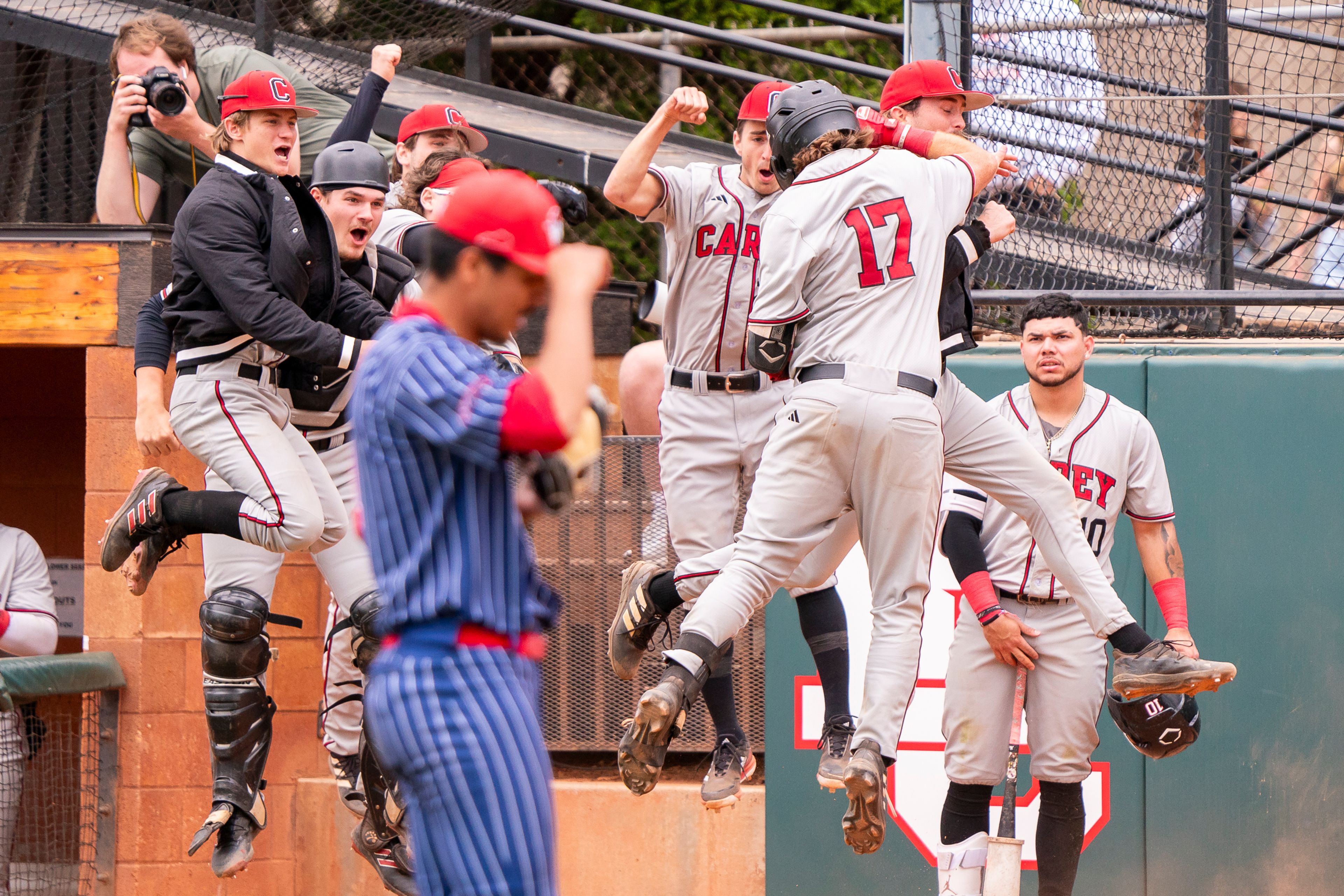 William Carey’s Braydon Coffey (17) celebrates with teammates after hitting a home run as Cumberlands pitcher Cesar Avila adjusts his hat during game 6 of the NAIA World Series on Saturday at Harris Field in Lewiston.