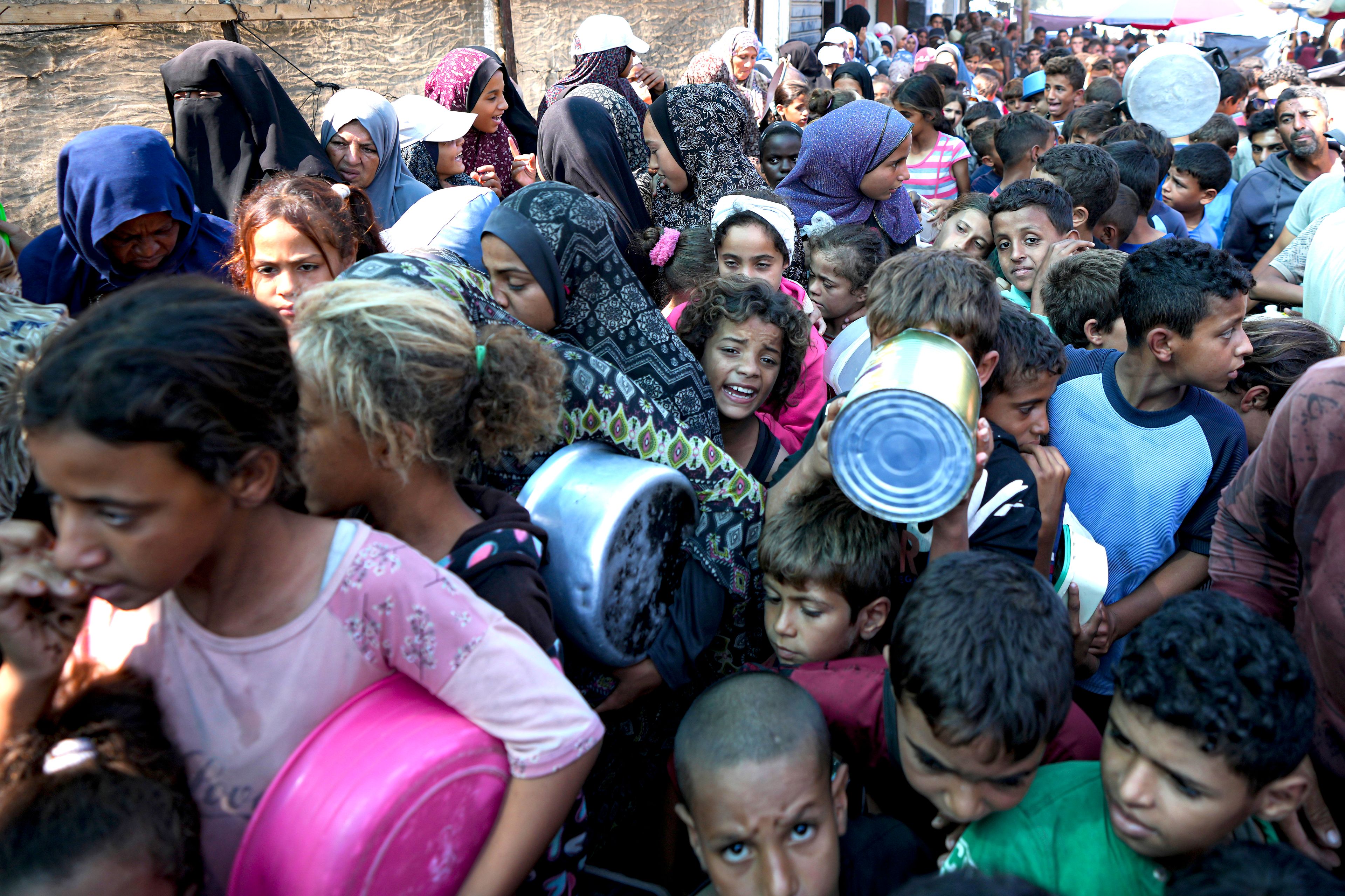 Palestinians line up for food distribution in Deir al-Balah, Gaza Strip, Thursday, Oct. 17, 2024. (AP Photo/Abdel Kareem Hana)