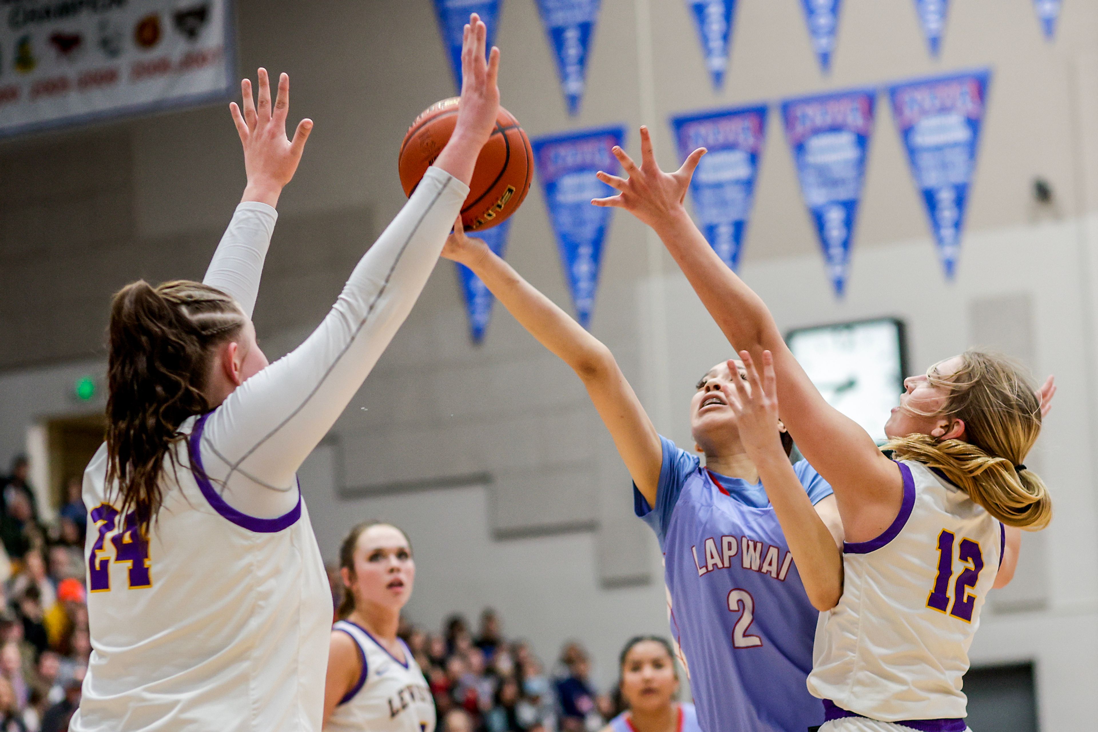 Lapwai point guard Jordyn McCormack-Marks, center right, shoots the ball as Lewiston post Addison McKarcher, right, guards her during Wednesday’s girls basketball semifinal in the Avista Holiday Tournament at the P1FCU Activity Center on the campus of Lewis-Clark State College.