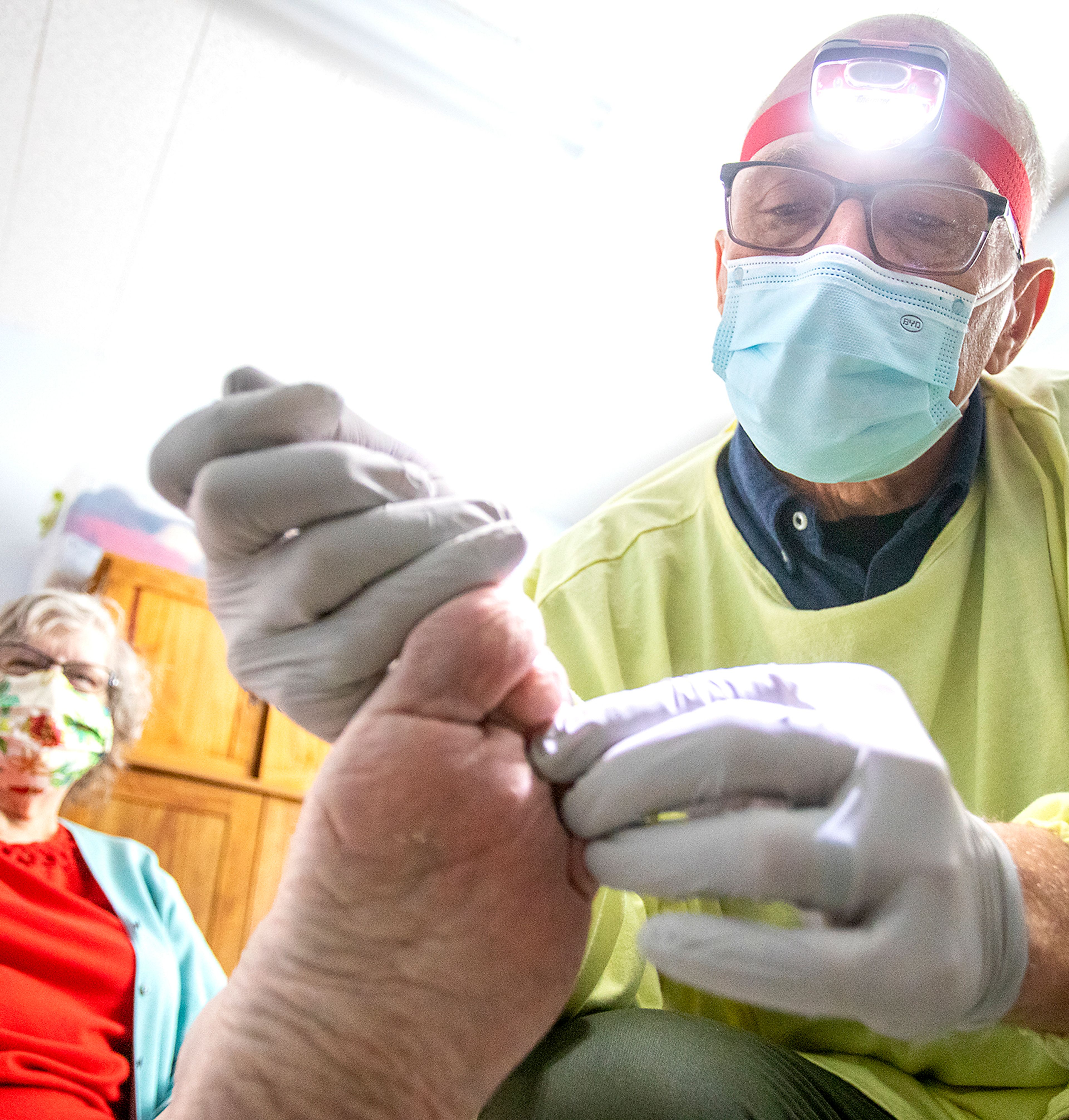 Nurse Aaron Loudenback clips the nails of Mary Lou Gregory in February.