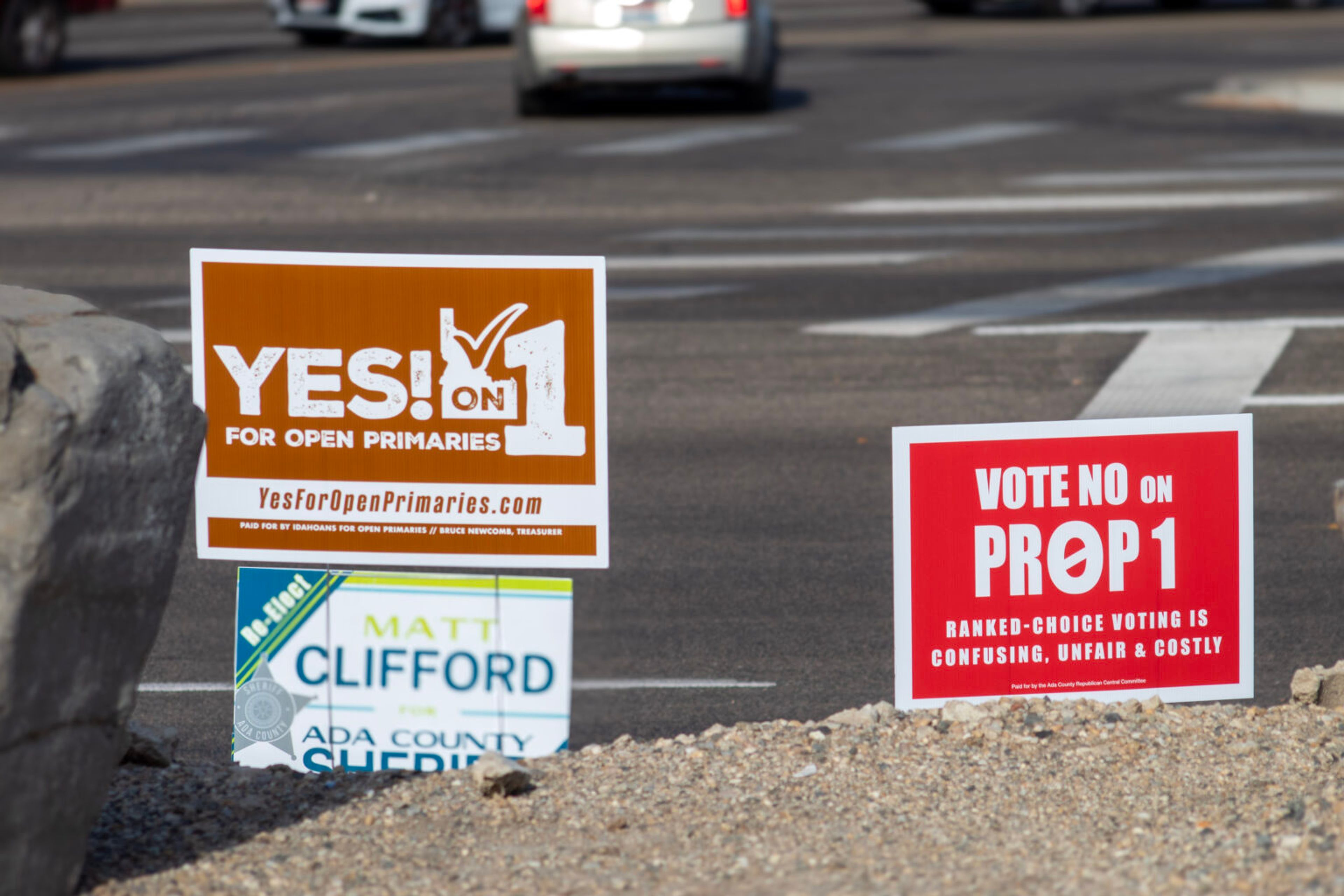 Two opposing signs funded by Idahoans for Open Primaries and the Ada County Republican Central Committee stand side by side on Federal Way in Boise.
