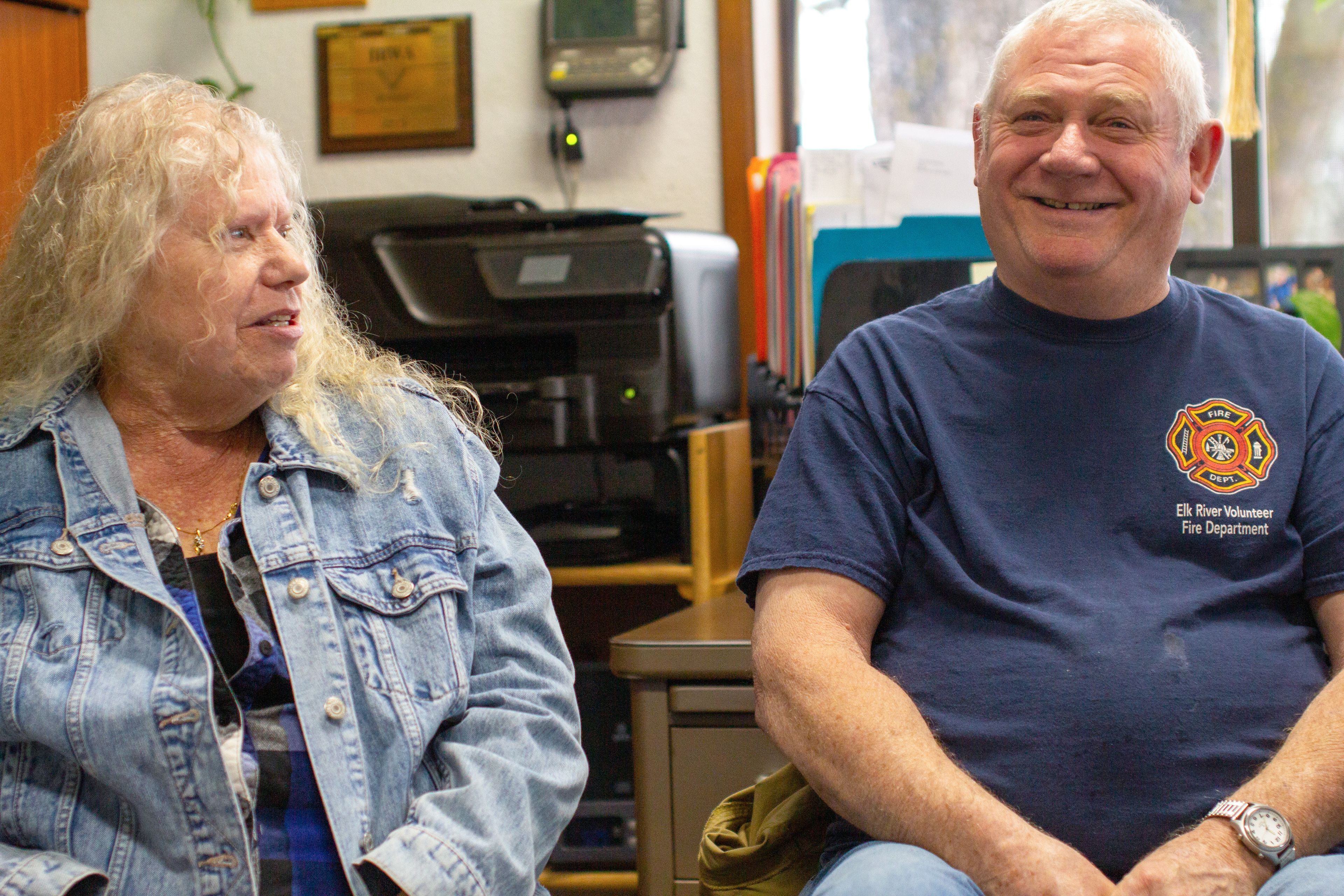 DeEtta Mitchell, left, talks with Fire Chief Wayne Wilson on Monday at Elk River City Hall. Mitchell helped monitor patients after their injections at the city’s COVID-19 vaccination clinics, and Wilson provided patients with rides to and from City Hall.