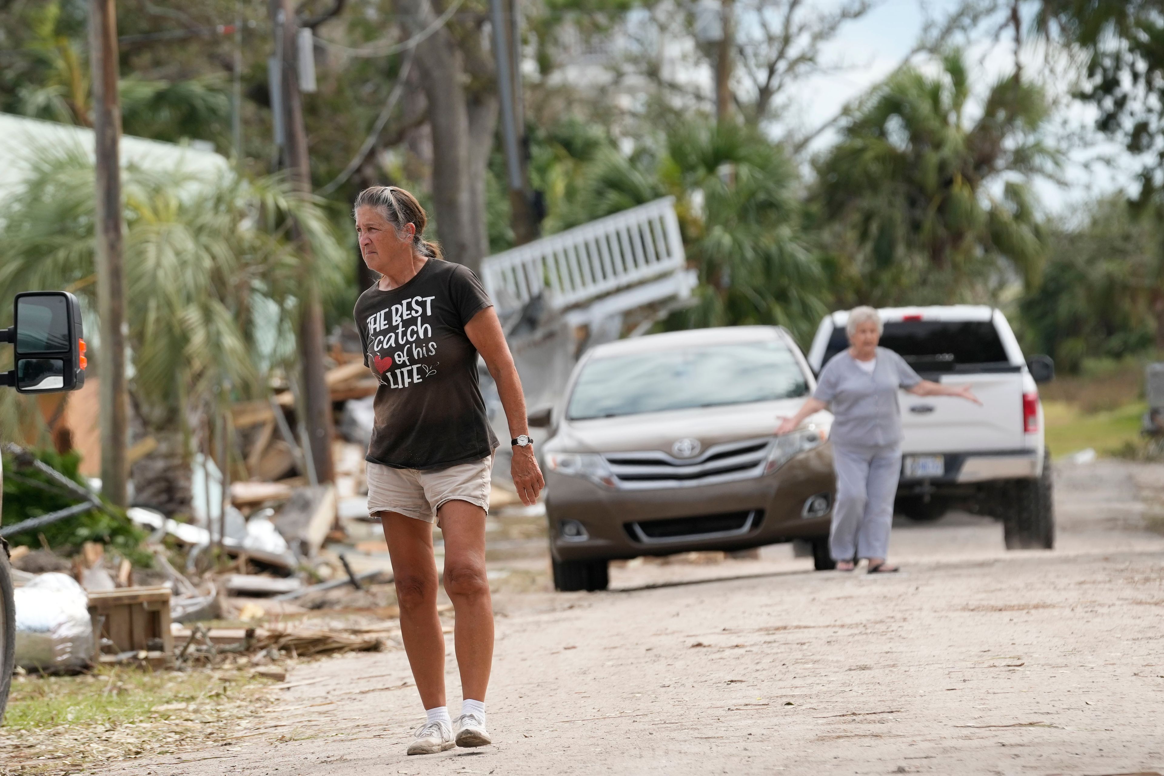 Residents walk amidst the destruction in the aftermath of Hurricane Helene, in Horseshoe Beach, Fla., Saturday, Sept. 28, 2024. (AP Photo/Gerald Herbert)