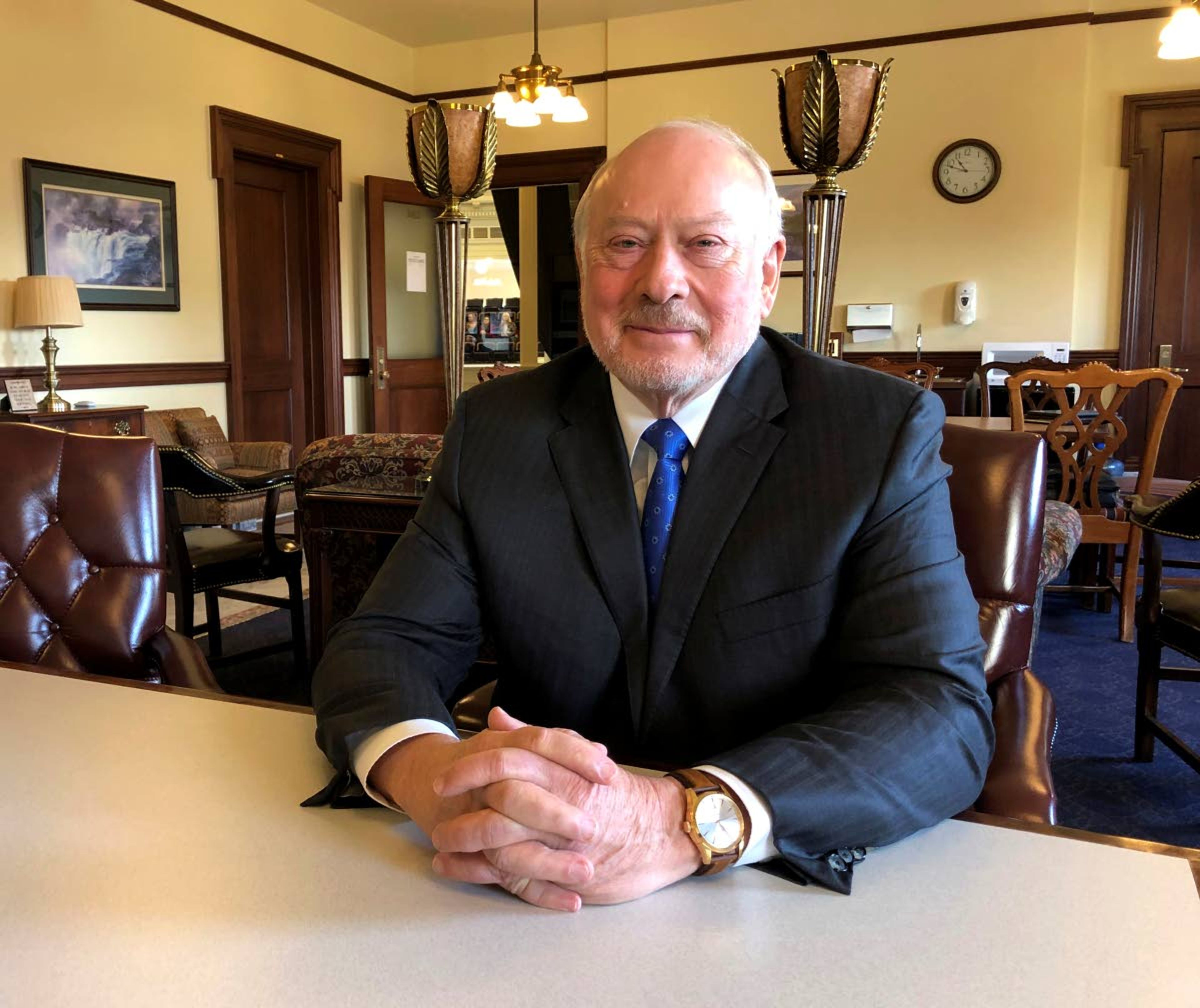 Frank VanderSloot poses at a table Wednesday on the fourth floor of the Idaho Statehouse in Boise. The 71-year-old billionaire founder of wellness shopping club Melaleuca says legislation is needed to protect families from unethical medical debt collectors.