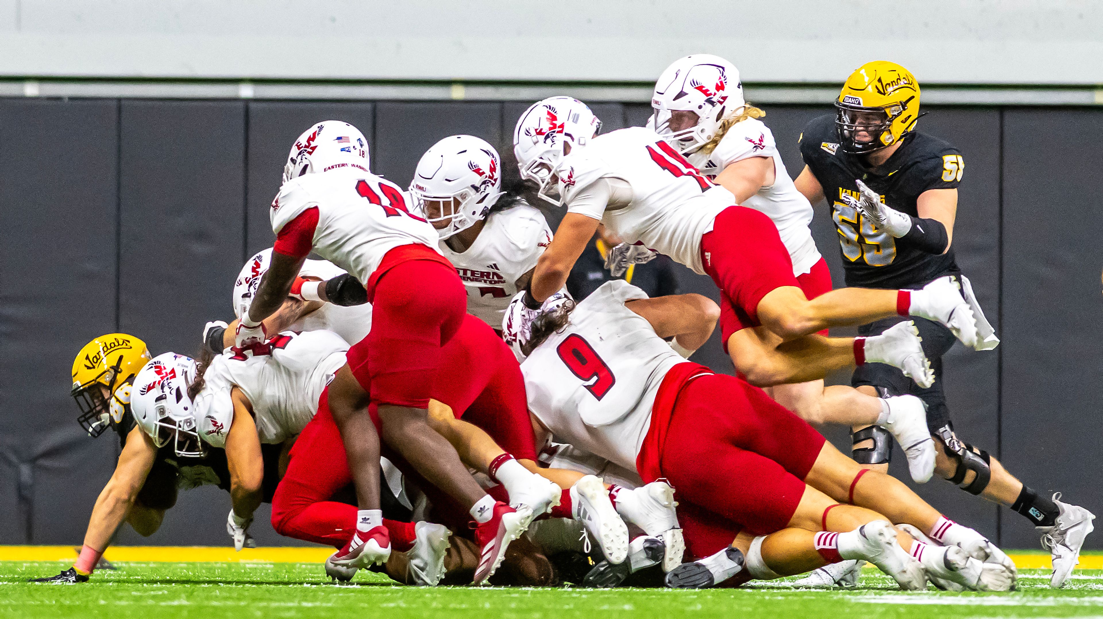 An Idaho ball carrier is tackled by numerous Eastern Washington players during a Big Sky game Saturday at the Kibbie Dome in Moscow. ,