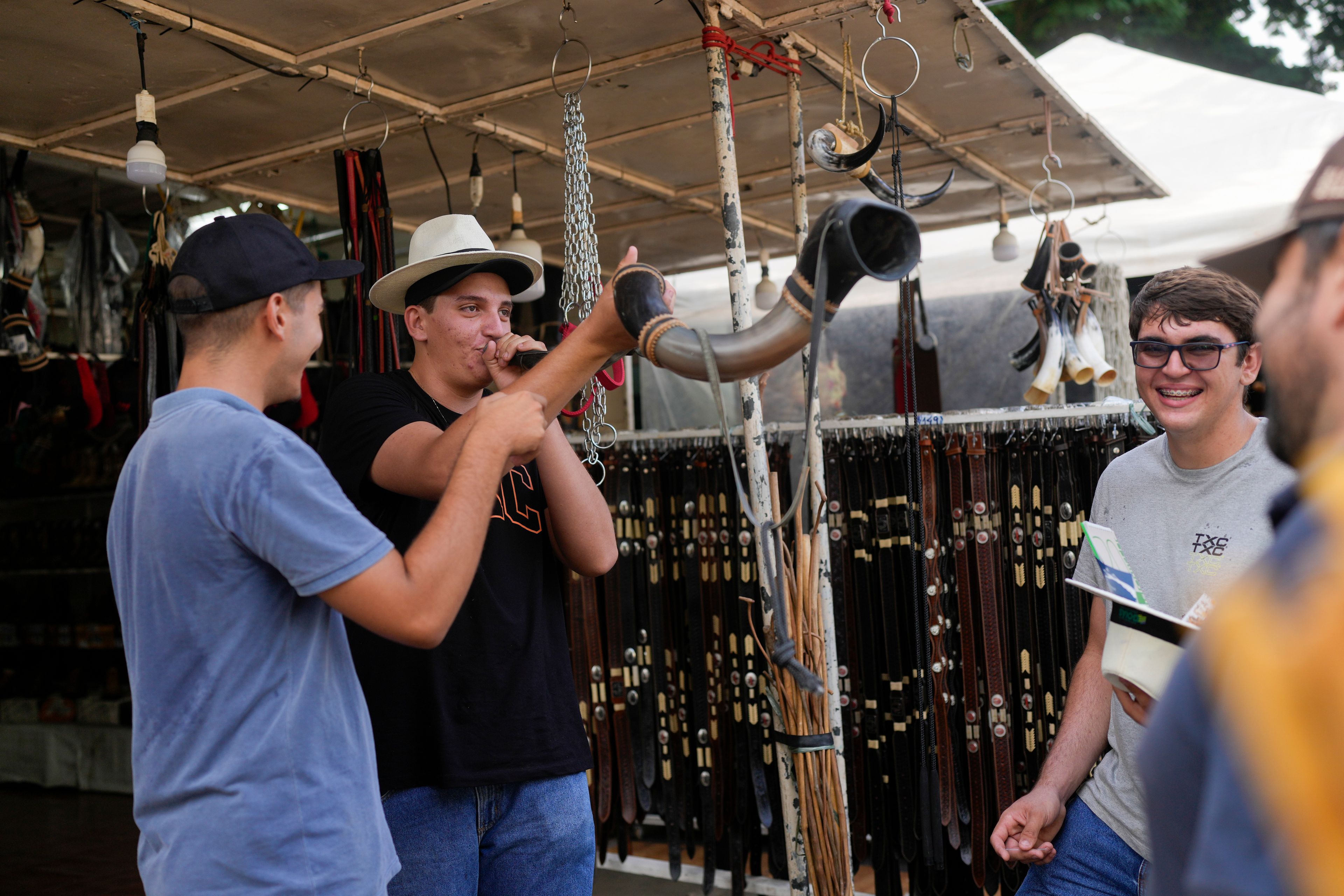 A youth blows into a horn at a vendor's stall at the ExpoZebu fair in Uberaba, Minas Gerais state, Saturday, April 27, 2024. Uberaba holds an annual gathering called ExpoZebu that bills itself as the world’s biggest Zebu fair.