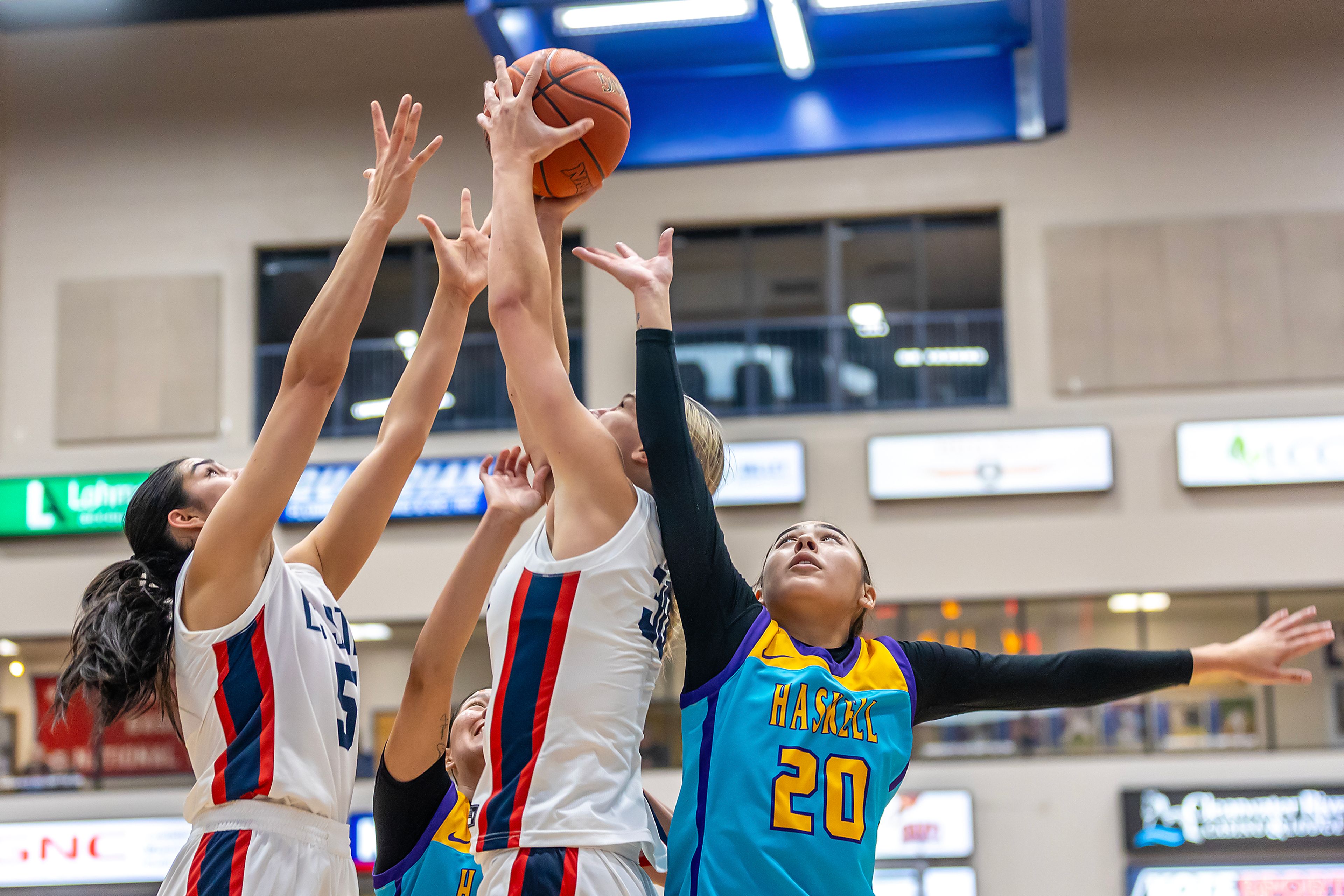 Lewis-Clark State forward Darian Herring grabs a rebound over Haskell guard Tierzah Penn during the season opening game as part of Tribal Nations Weekend Saturday in Lewiston.,