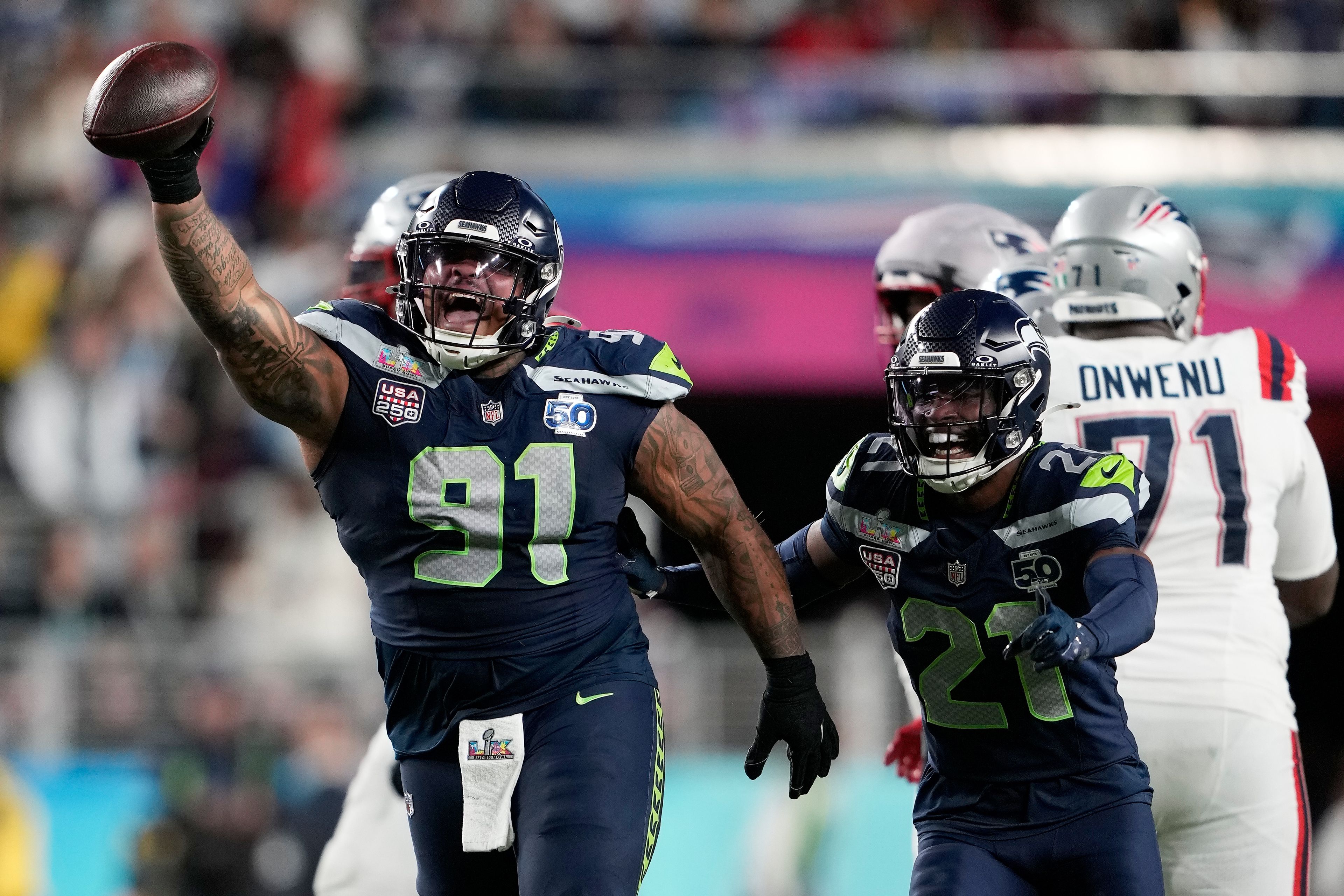 Seahawks defensive tackle Byron Murphy II (91) celebrates with cornerback Devon Witherspoon (21) after recovering a fumble by Patriots quarterback Drake Maye during the second half of Super Bowl LX on Feb. 8, 2026, in Santa Clara, Calif.




