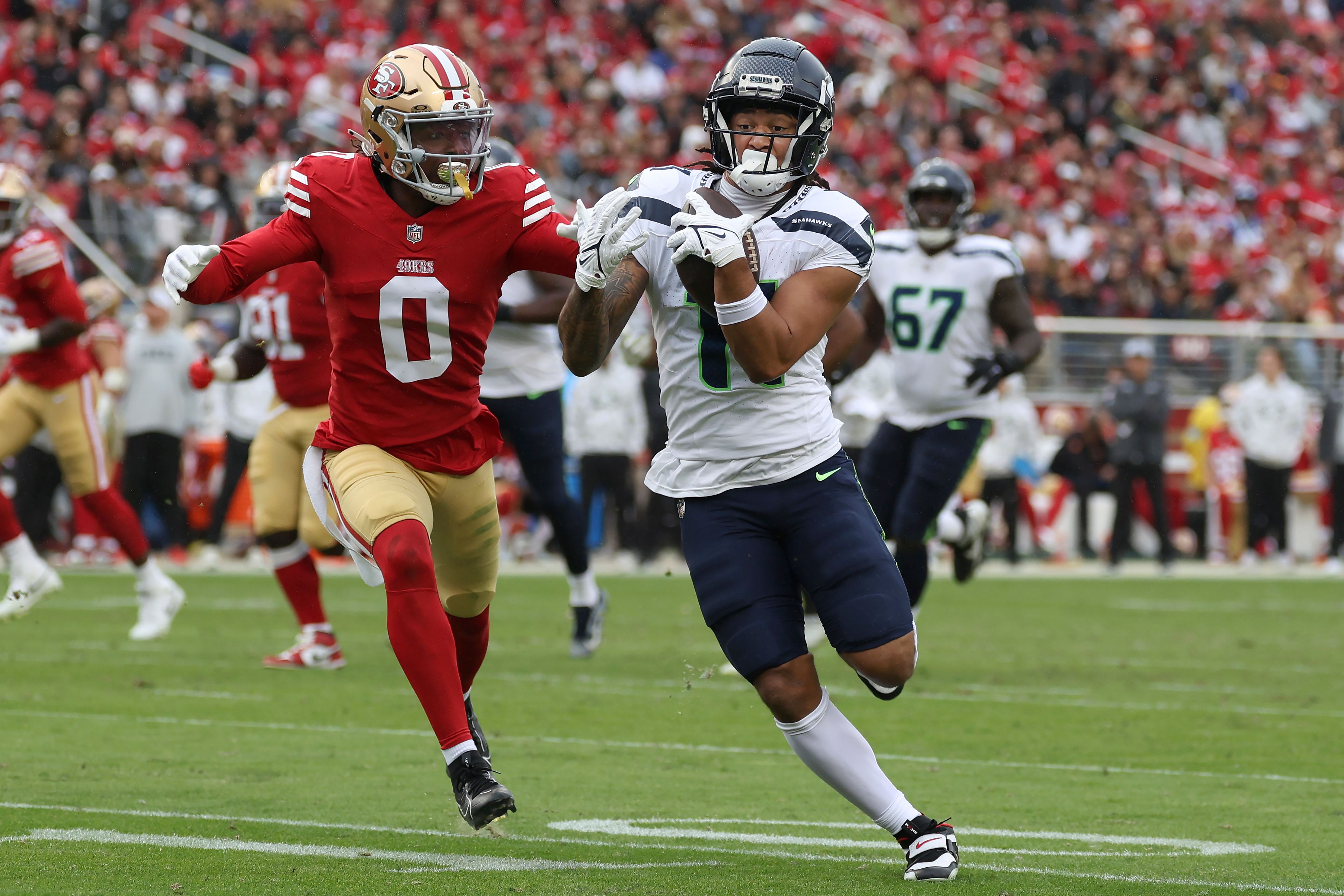 Seattle Seahawks wide receiver Jaxon Smith-Njigba, foreground right, runs against San Francisco 49ers cornerback Renardo Green (0) during the second half of an NFL football game in Santa Clara, Calif., Sunday, Nov. 17, 2024. (AP Photo/Jed Jacobsohn)