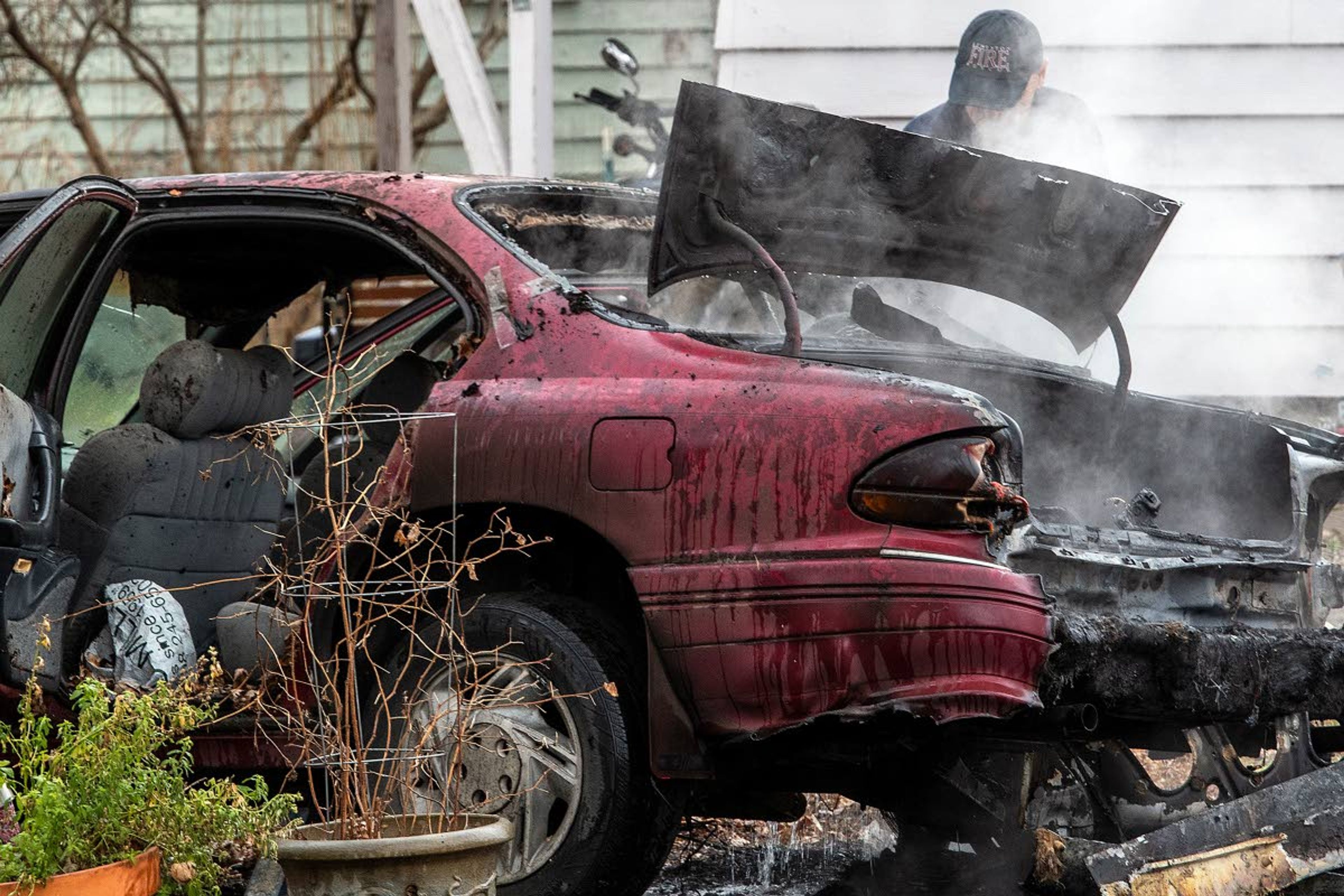 A firefighter from the Lewiston Fire Department inspects the remains of a sedan that caught fire Tuesday morning along the 1000 block of Airway Avenue in the Lewiston Orchards. No injuries were reported, but the car appeared to be a total loss.