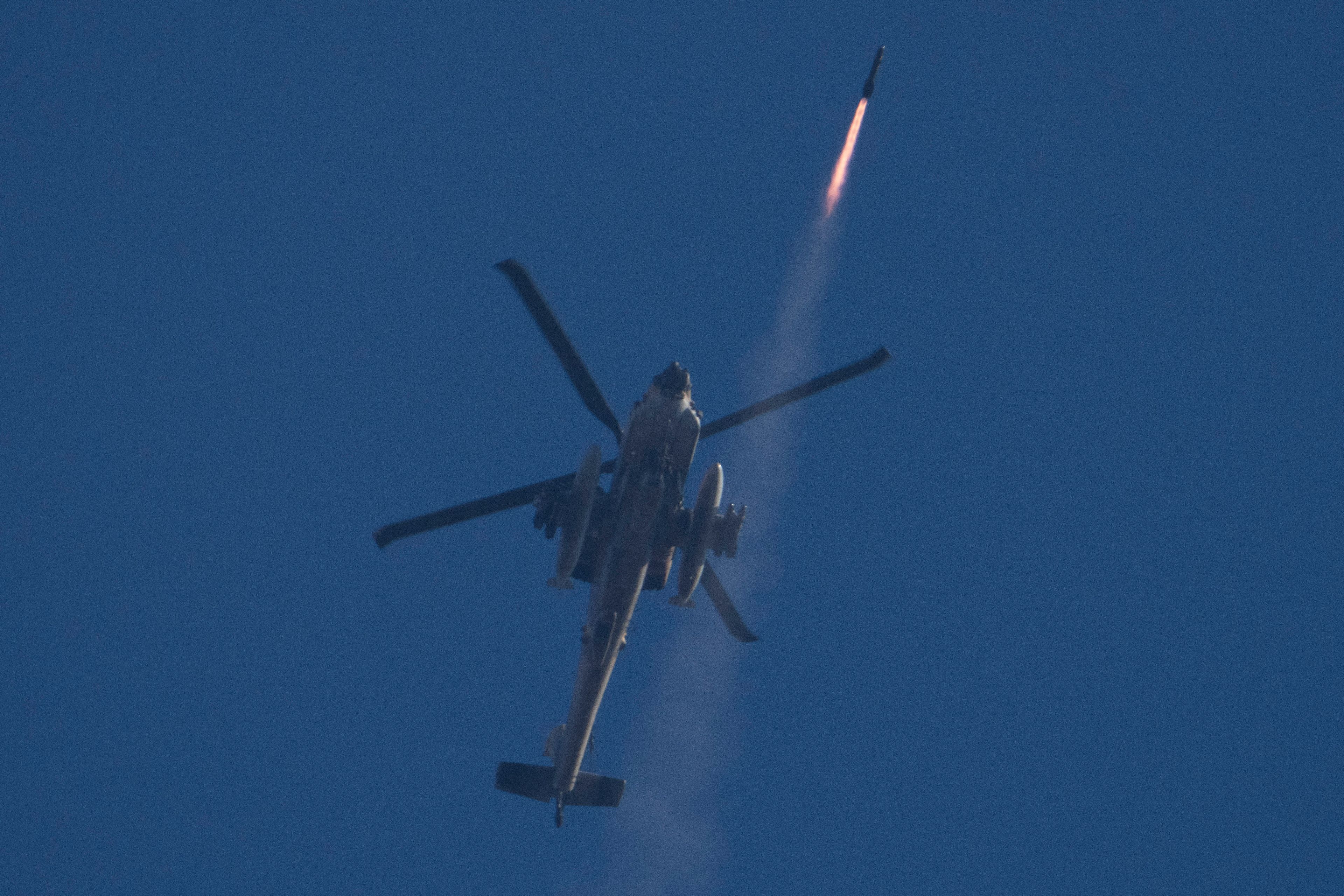 An Israeli Apache helicopter fires a missile towards southern Lebanon as seen from northern Israel, Friday, Oct. 4, 2024. (AP Photo/Leo Correa)