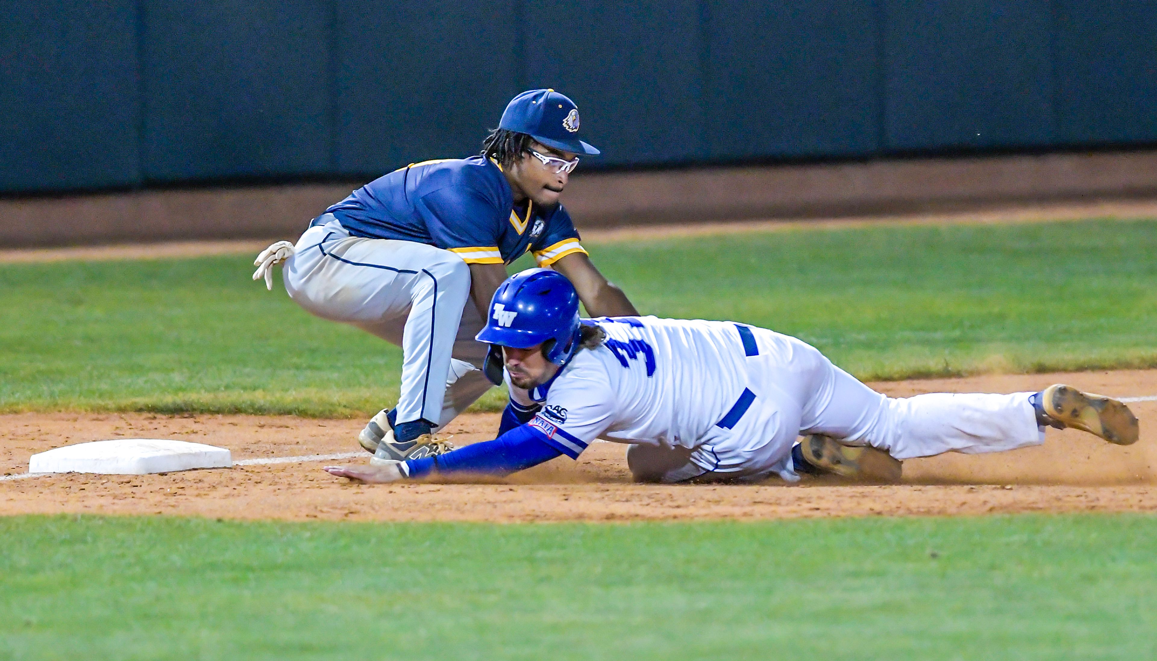 Reinhardt third baseman Jarrett Burney tags out Tennessee Wesleyan Chad Picton to send the game into extra innings in Game 18 of the NAIA World Series at Harris Field Thursday in Lewiston.