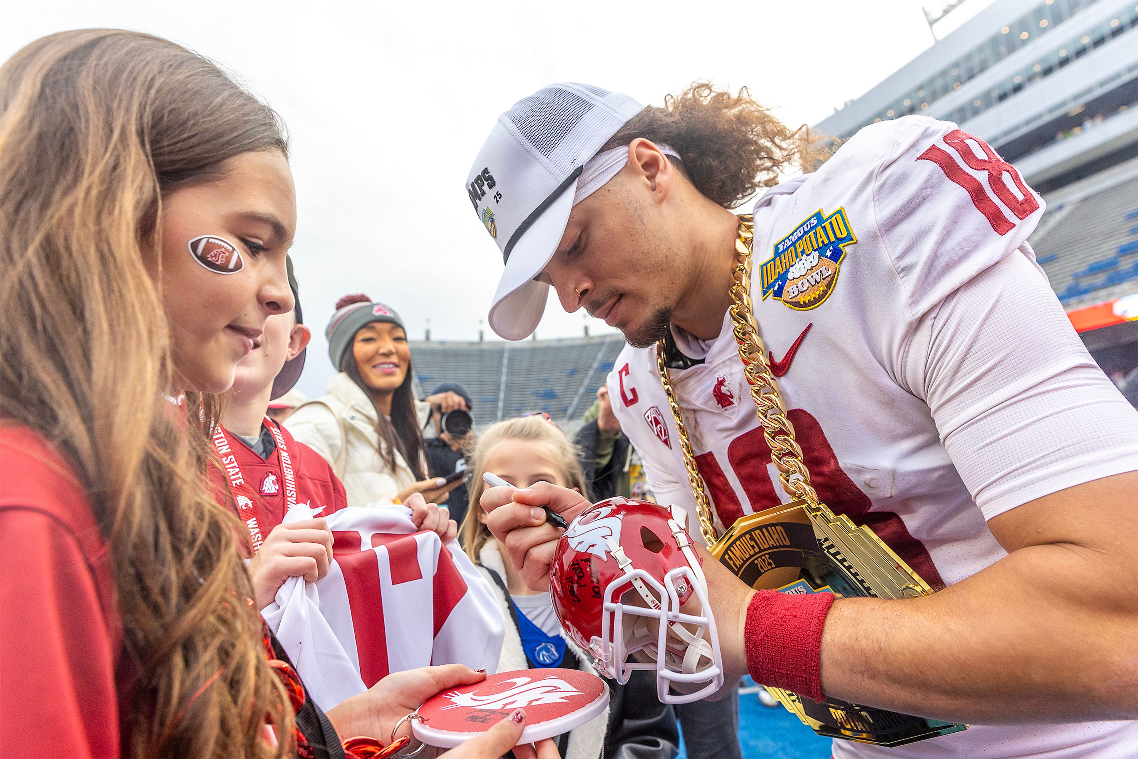 Washington State wide receiver Joshua Meredith signs autographs following the Famous Idaho Potato Bowl Monday at Albertsons Stadium in Boise. Washington State defeated Utah State 34-21.