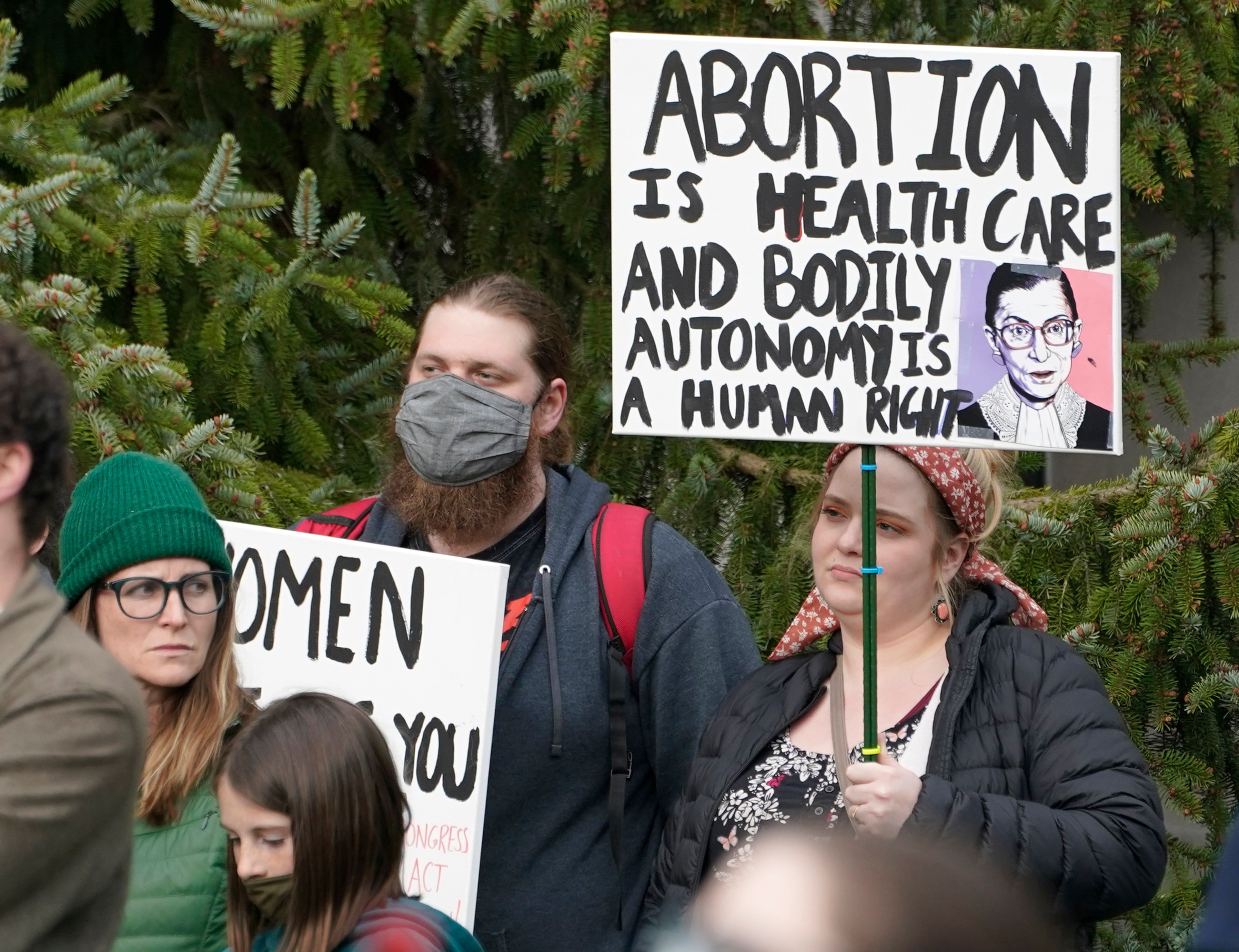 A person holds a sign with an image of former Supreme Court Justice Ruth Bader Ginsburg as they take part in a rally in favor of abortion rights, Tuesday, May 3, 2022, at the Capitol in Olympia, Wash. (AP Photo/Ted S. Warren)