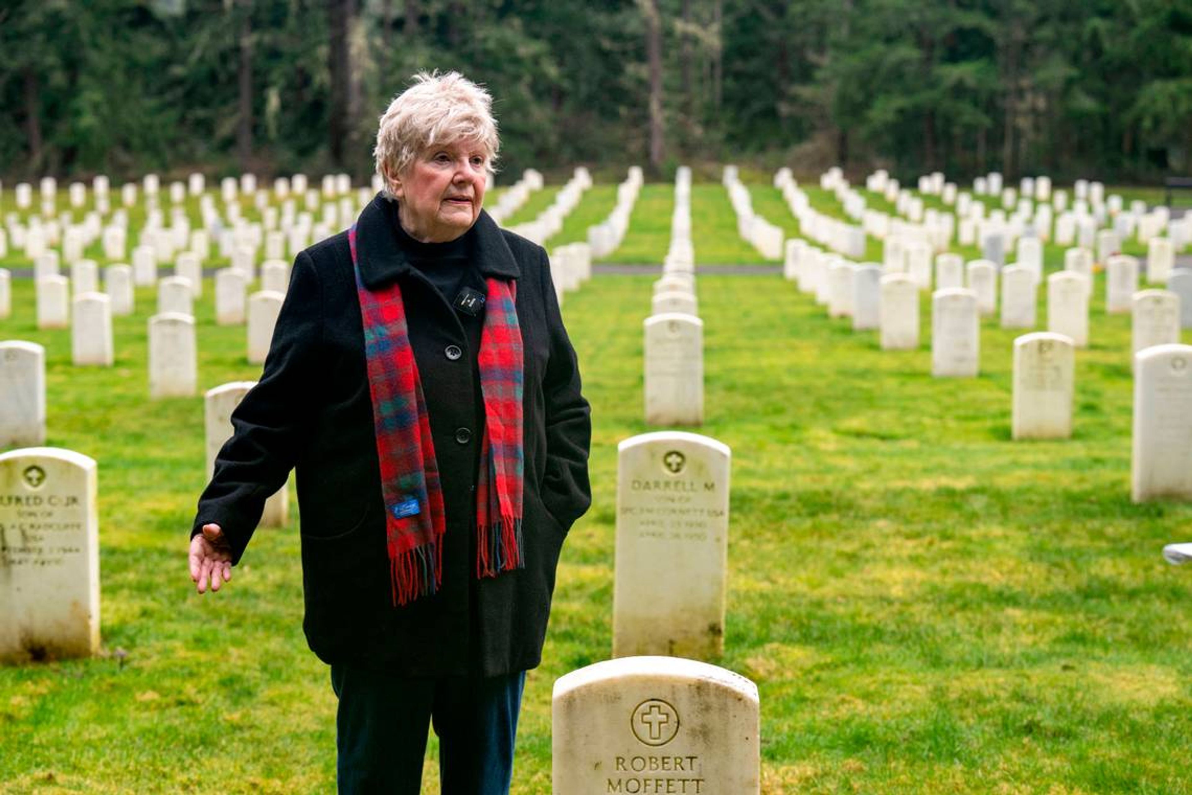 Mary Dowling stands at the grave of her husband, Bob, Jan. 24 while pointing toward the site where she was supposed to be buried alongside him in the Camp Lewis Cemetery at Joint Base Lewis-McChord. Pete Caster Pete Caster / The News Tribune