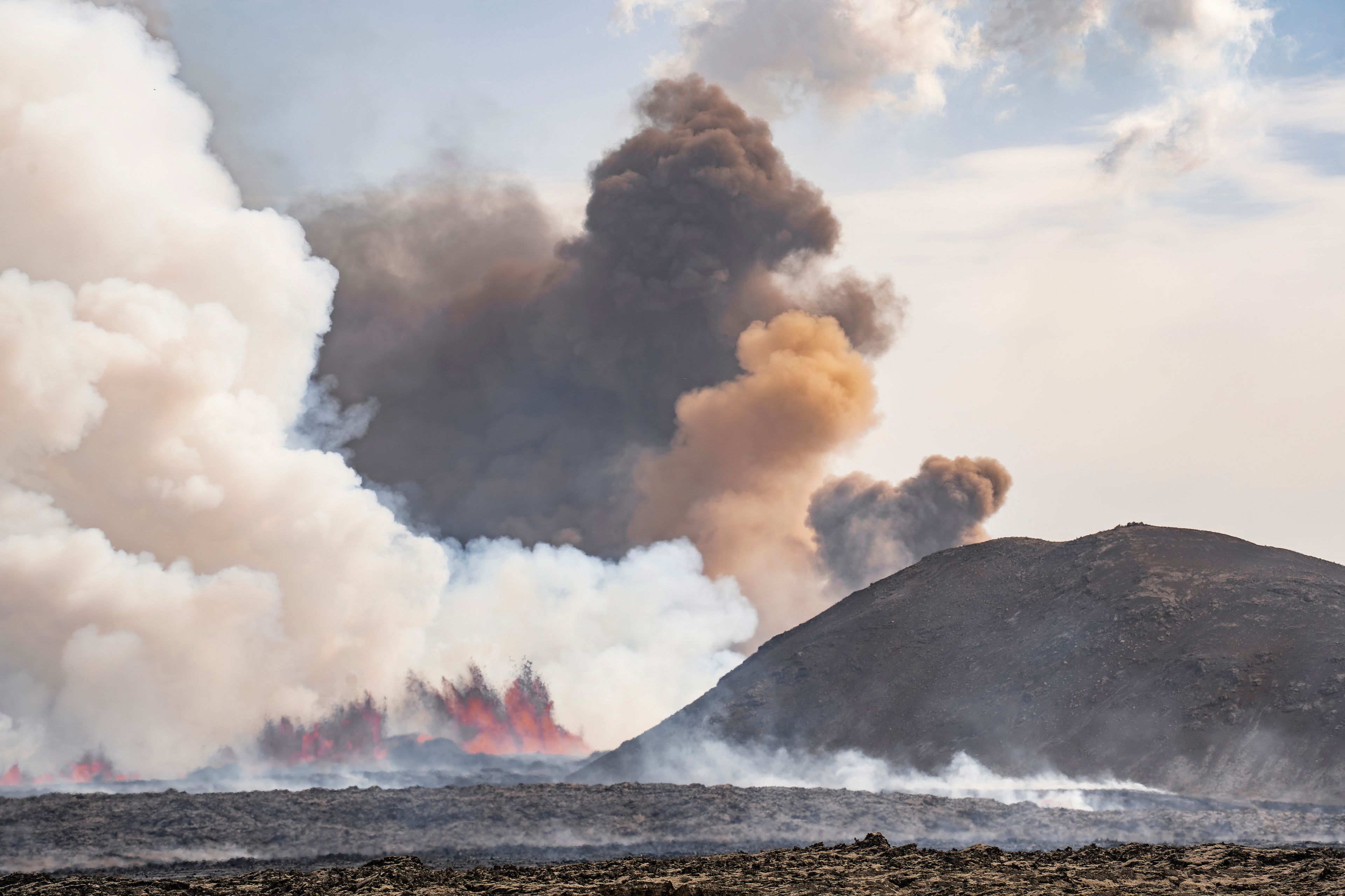 Ash rising behind Sýlingarfell, as magma hits groundwater triggering phreatomagmatic activity from a volcano in Grindavik, Iceland, Wednesday, May 29, 2024. A volcano in southwestern Iceland erupted Wednesday for the fifth time since December, spewing red lava that once again threatened the coastal town of Grindavik and led to the evacuation of the popular Blue Lagoon geothermal spa.