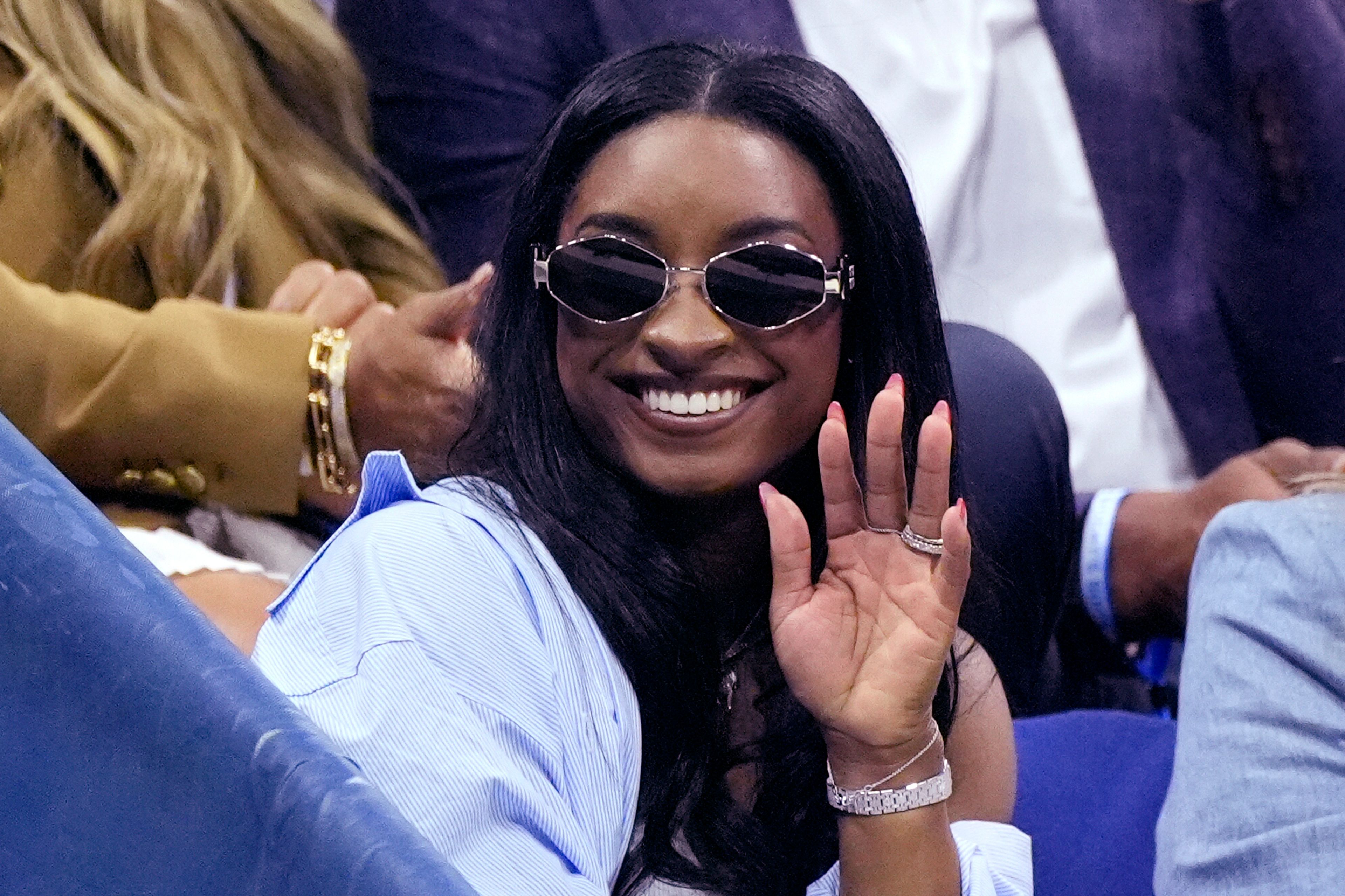 Olympic gold medalist Simone Biles waves during a break in a match between Jessica Pegula, of the United States, and Iga Świątek, of Poland, during the quarterfinals of the U.S. Open tennis championships, Wednesday, Sept. 4, 2024, in New York.