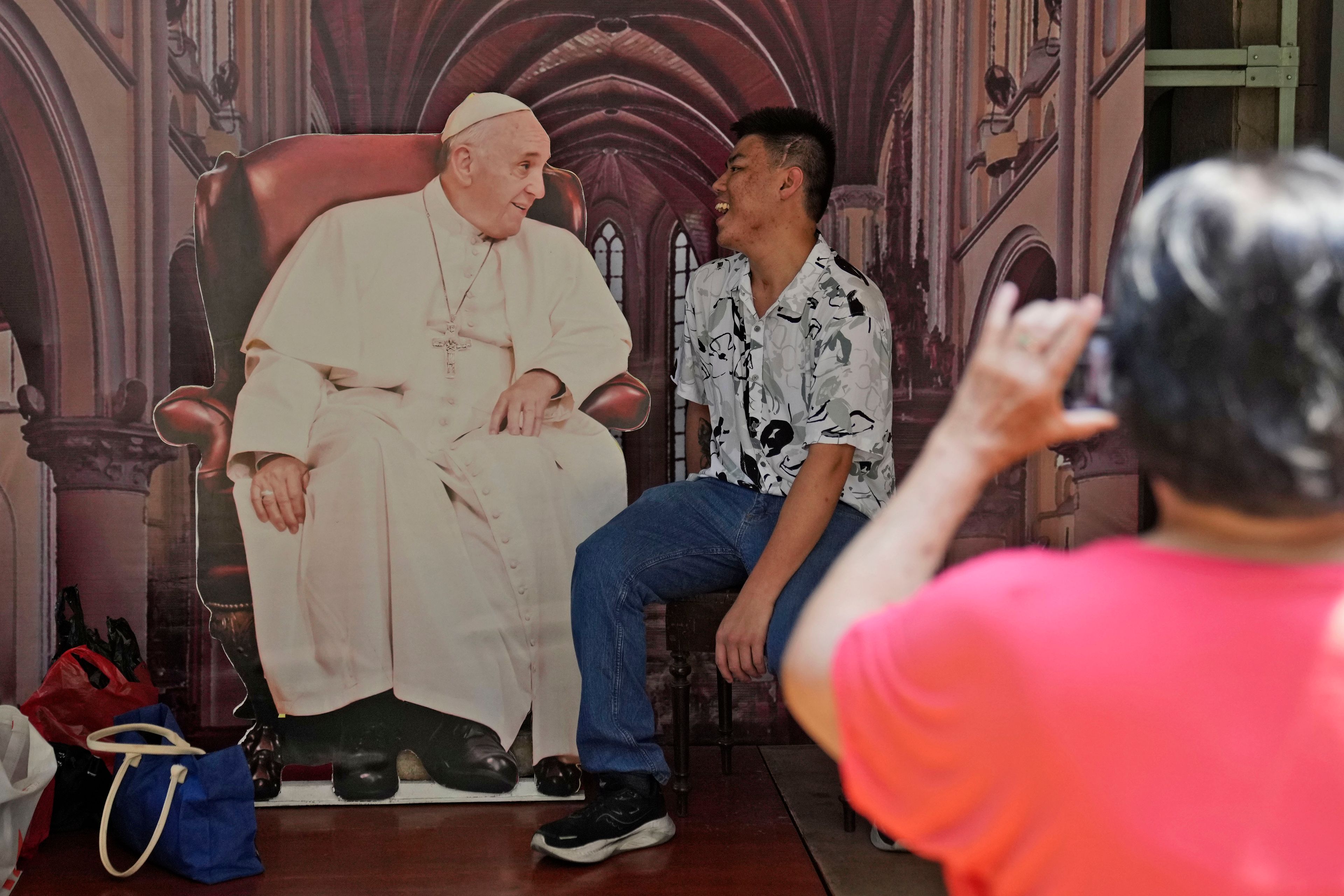 A man has his photo taken with a cutout of Pope Francis displayed at Jakarta Cathedral ahead of his visit to Indonesia from Sept. 3-6, in Jakarta, Indonesia, Sunday, Sept. 1, 2024.