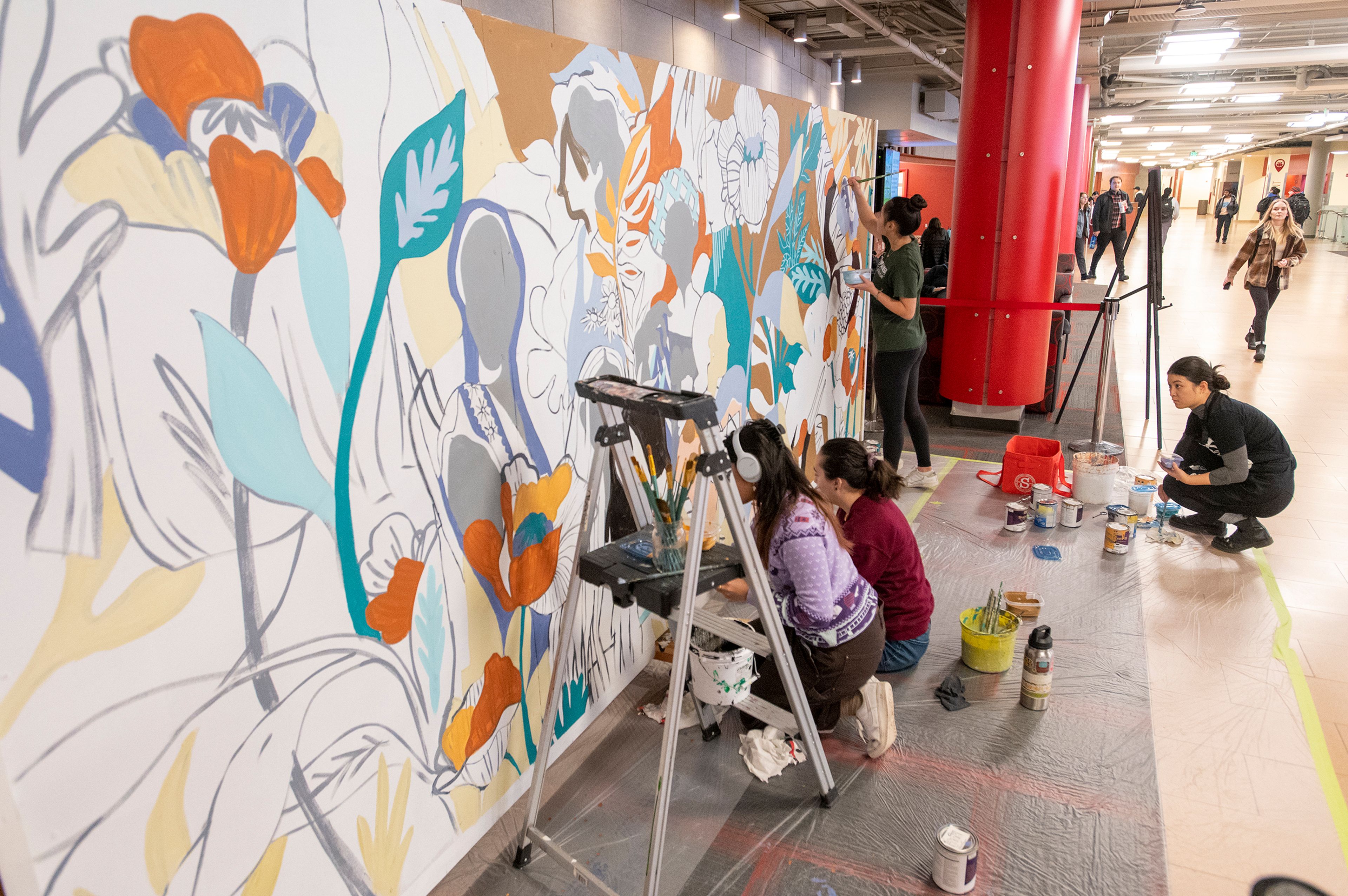 Artists Jiemei Lin, Reika Pratt, Kari Samio and Heidi Lee paint a mural Tuesday at Washington State University’s Compton Union Building in Pullman for the National Day of Racial Healing.