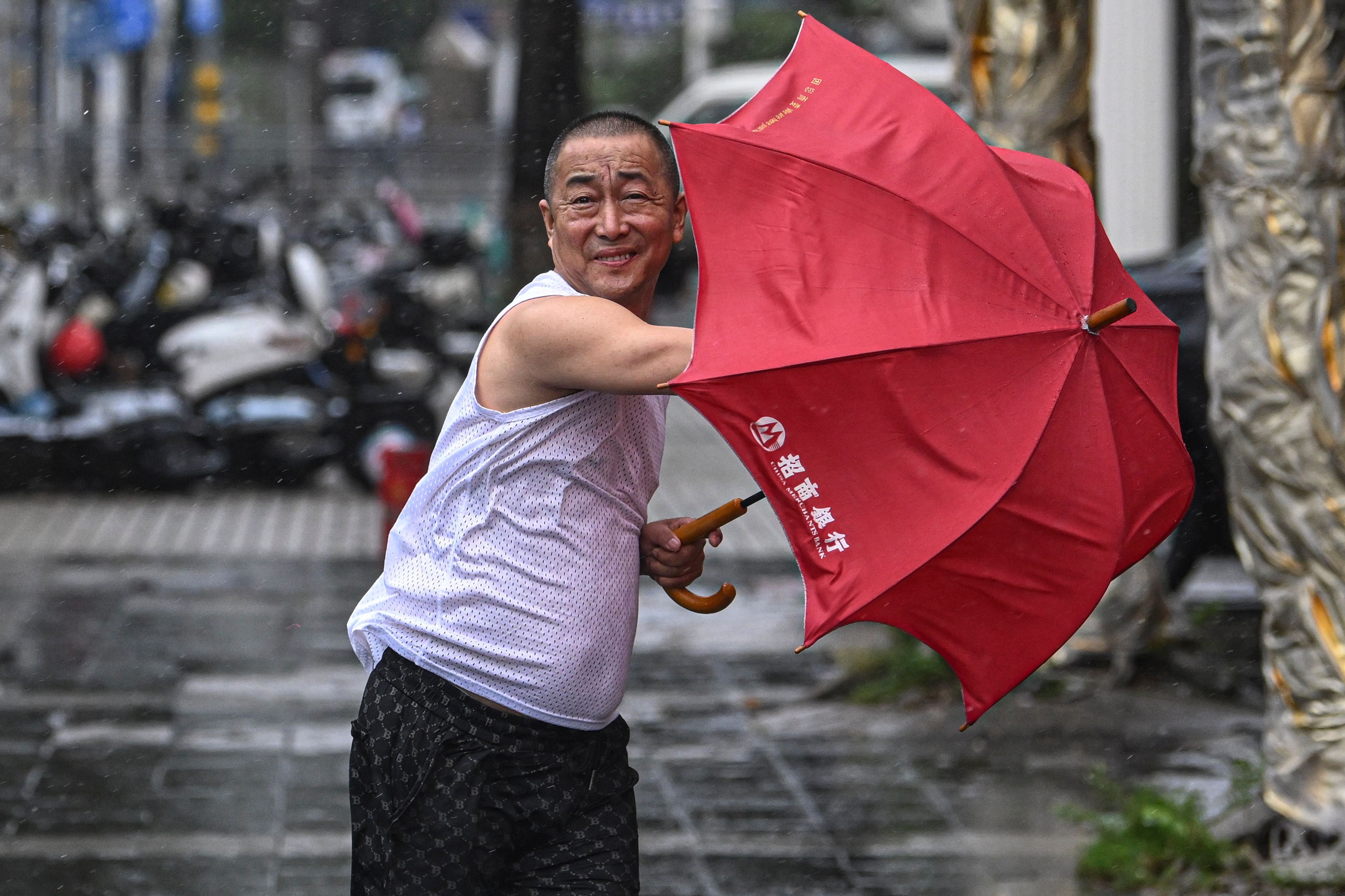 In this photo released by Xinhua News Agency, a man holding an umbrella struggles against the wind following the landfall of typhoon Yagi in Haikou, south China's Hainan Province, Friday, Sept. 6, 2024.