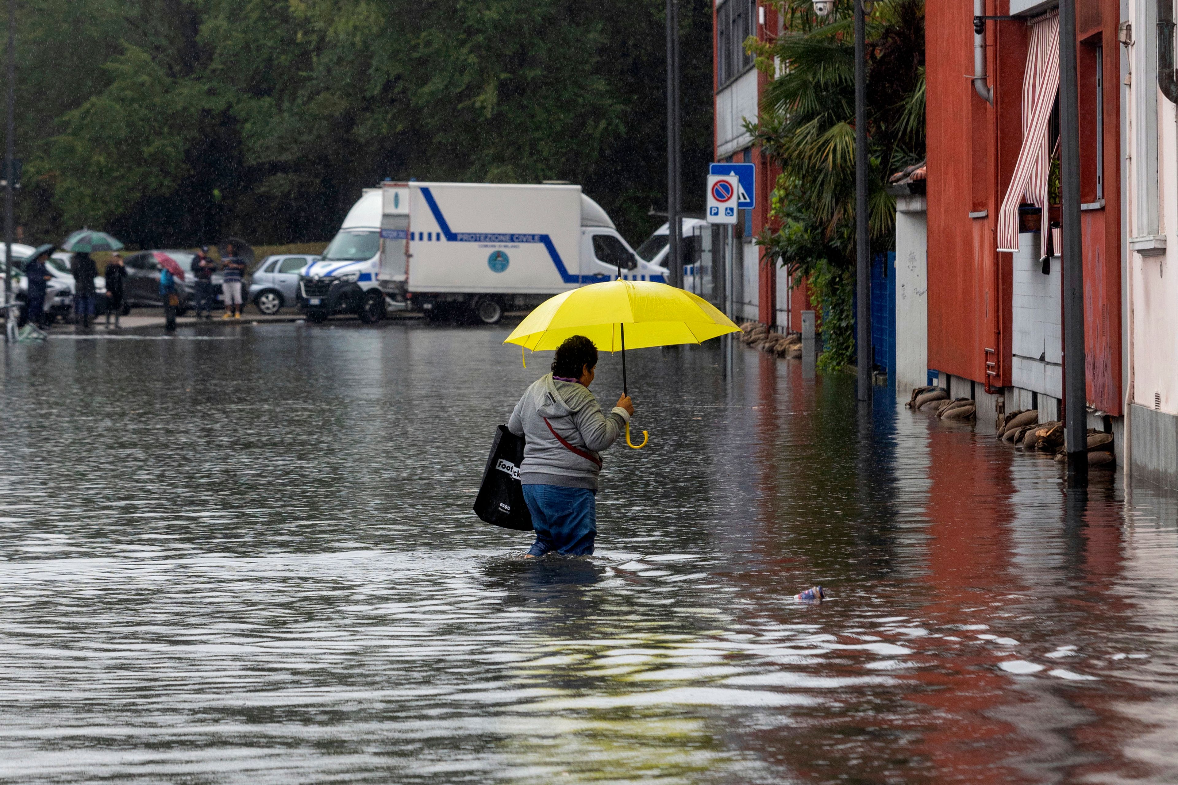 A woman wades through floodwater due to heavy rain in a street in Milan, Italy, Thursday Sept. 5, 2024.