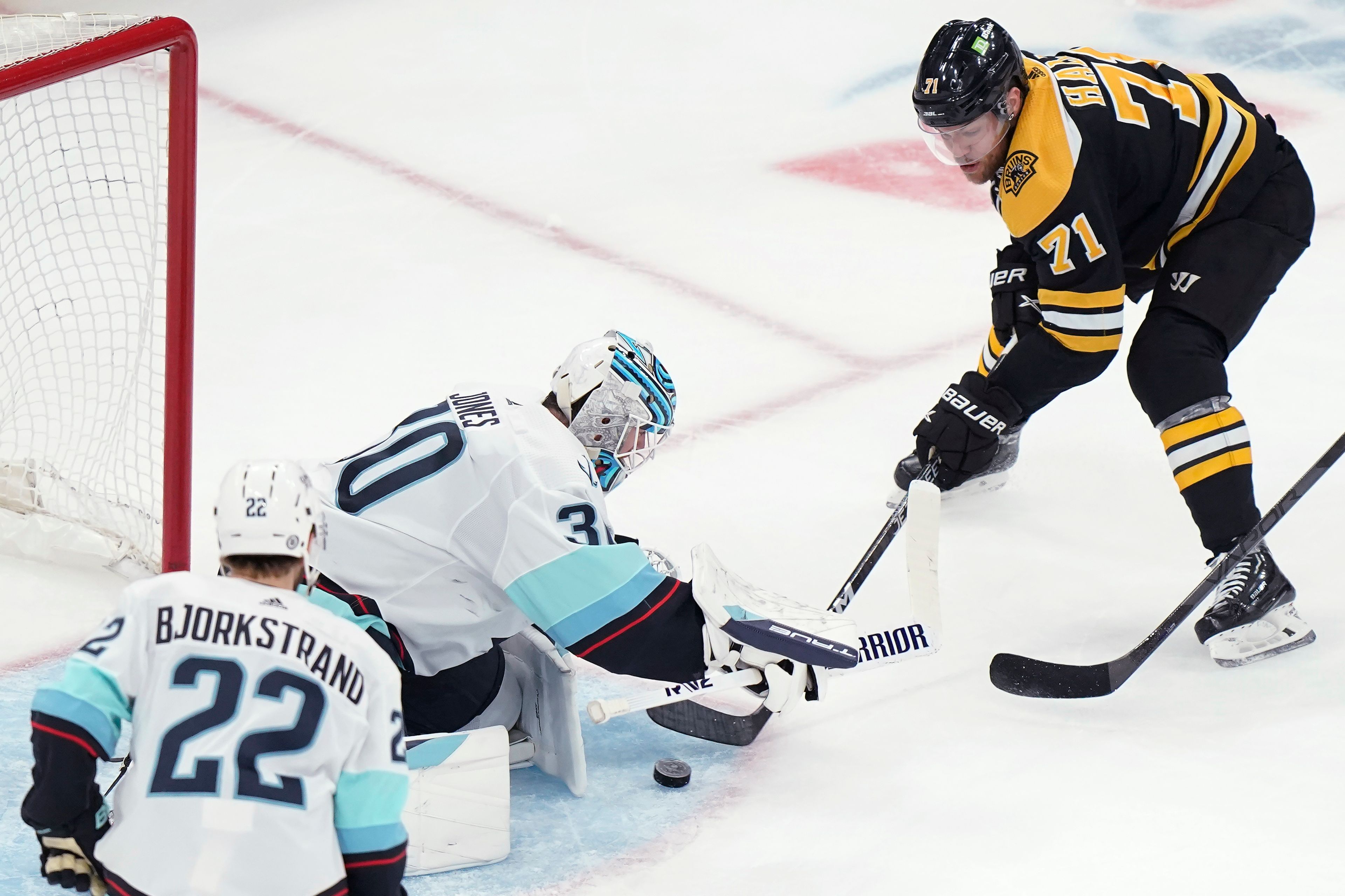 Boston Bruins left wing Taylor Hall (71) is unable to get the puck past Seattle Kraken goaltender Martin Jones (30) while Kraken right wing Oliver Bjorkstrand (22) watches during the second period of an NHL hockey game Thursday, Jan. 12, 2023, in Boston. (AP Photo/Steven Senne)