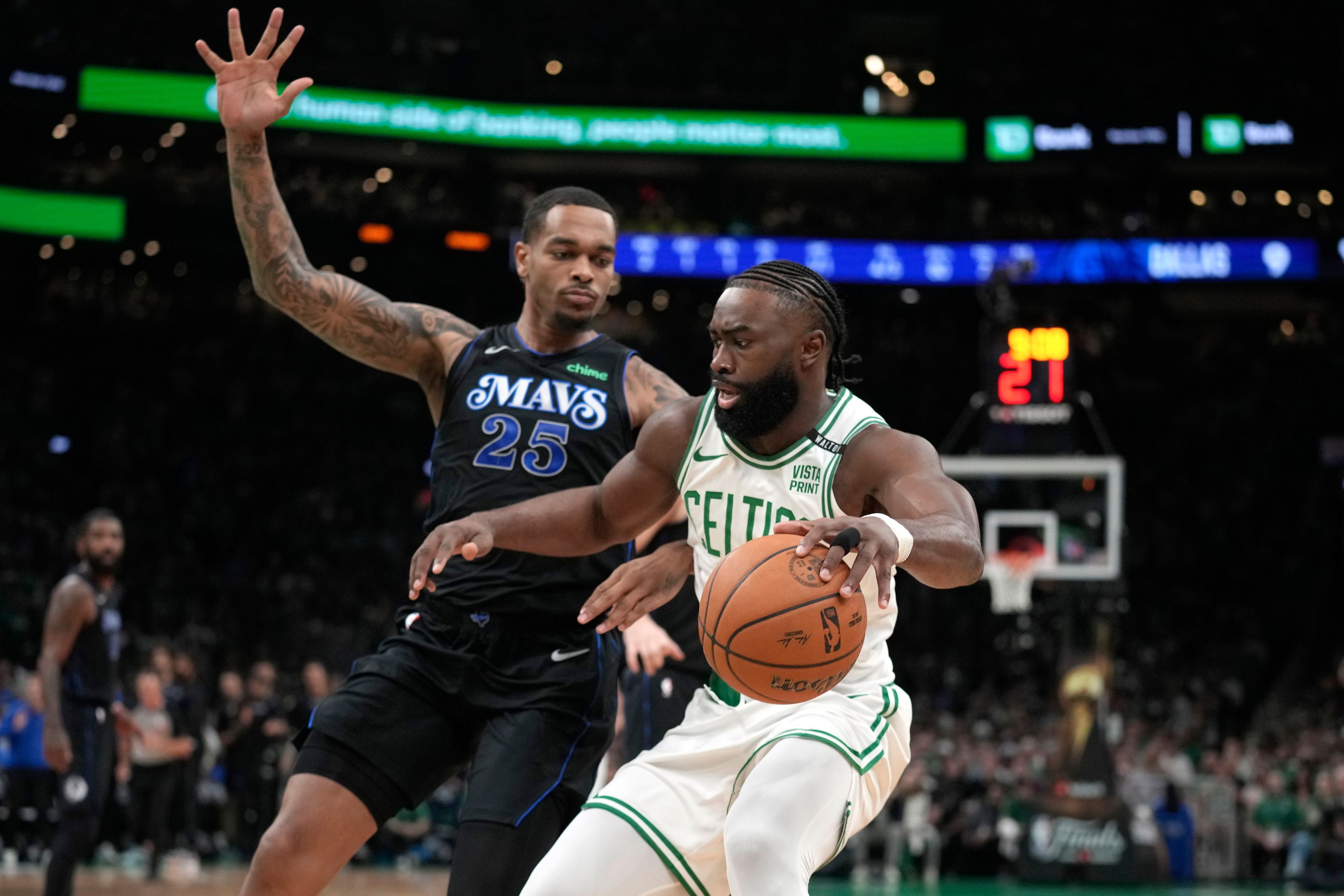 Boston Celtics guard Jaylen Brown, right, drives toward the basket as Dallas Mavericks forward P.J. Washington defends during the first half of Game 1 of basketball's NBA Finals on Thursday, June 6, 2024, in Boston.