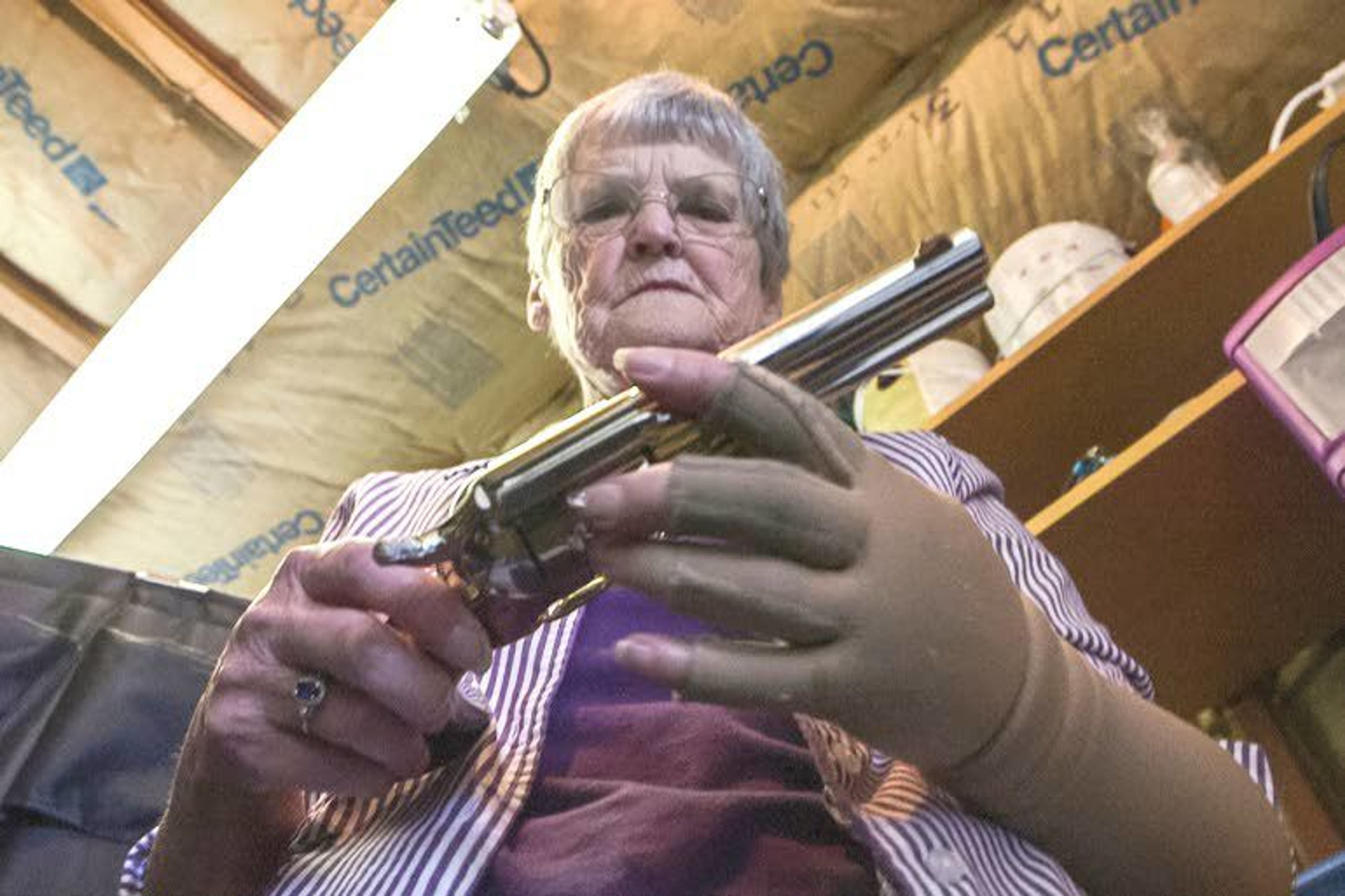 Dee Hill examines the last of the guns that once belonged to her husband, Darrell Hill, who shot her while she was caring for him during a rapidly progressing dementia. “I no longer have any guns in my home,” she says.