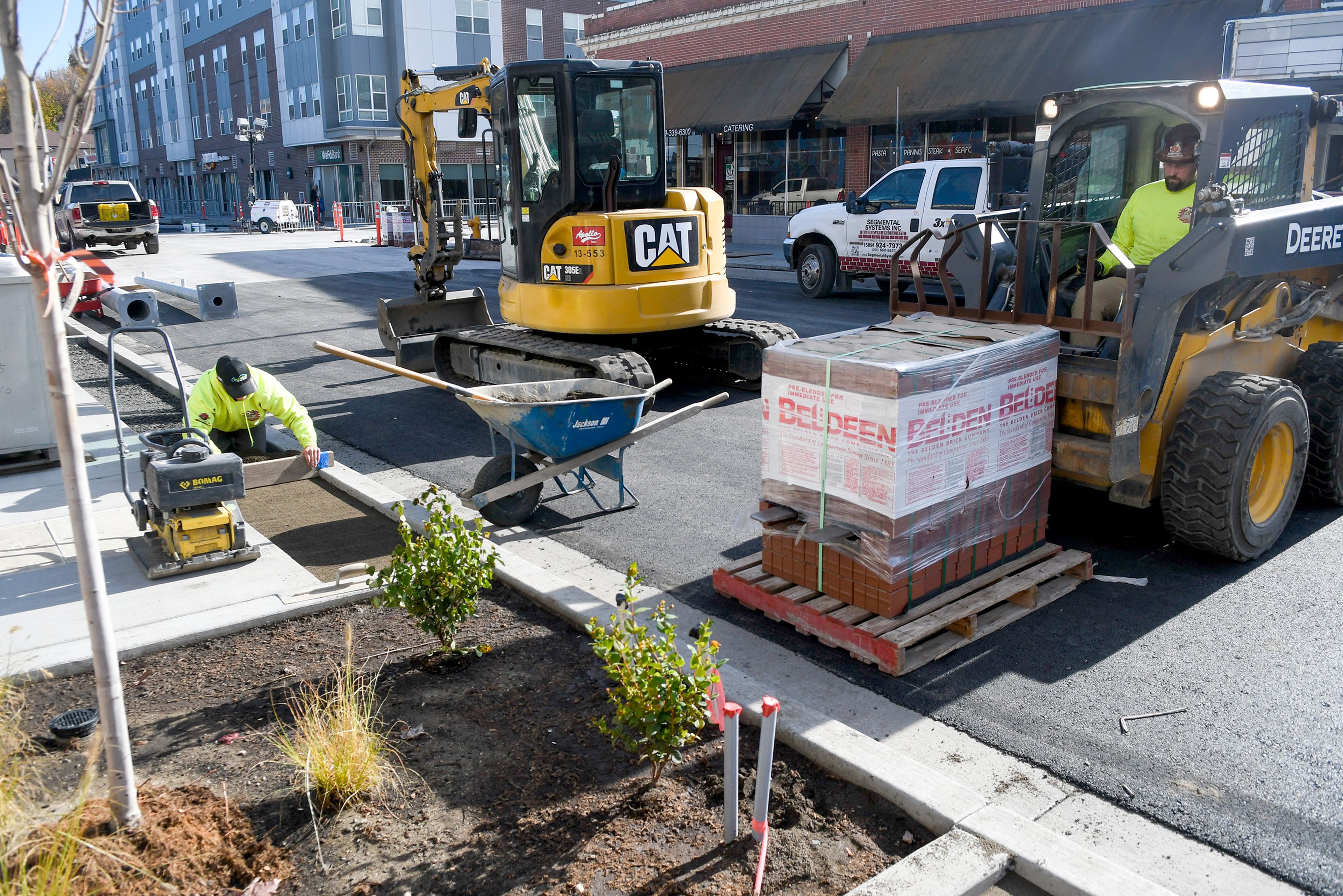 A crew with Segmental Systems works to place pavers Wednesday along the sidewalks of Main Street in downtown Pullman.