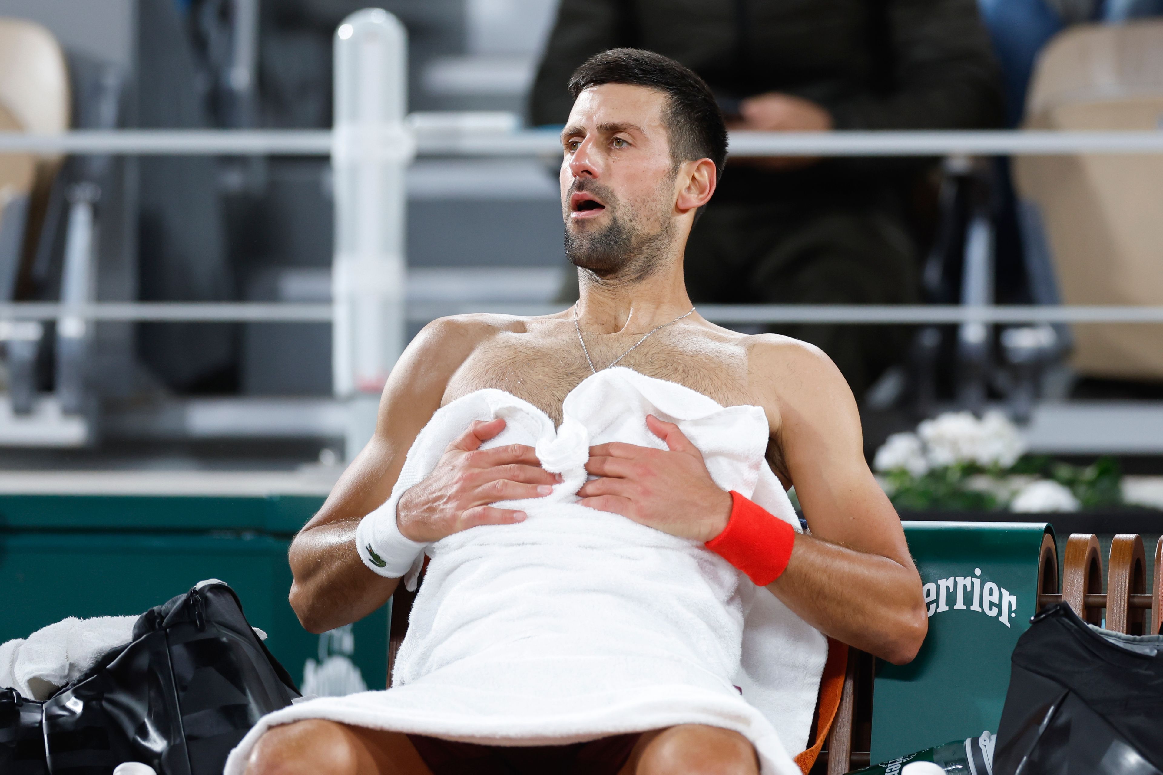 Serbia's Novak Djokovic catches his breath during a changeover in his third round match of the French Open tennis tournament against Italy's Lorenzo Musetti at the Roland Garros stadium in Paris, Sunday, June 2, 2024.